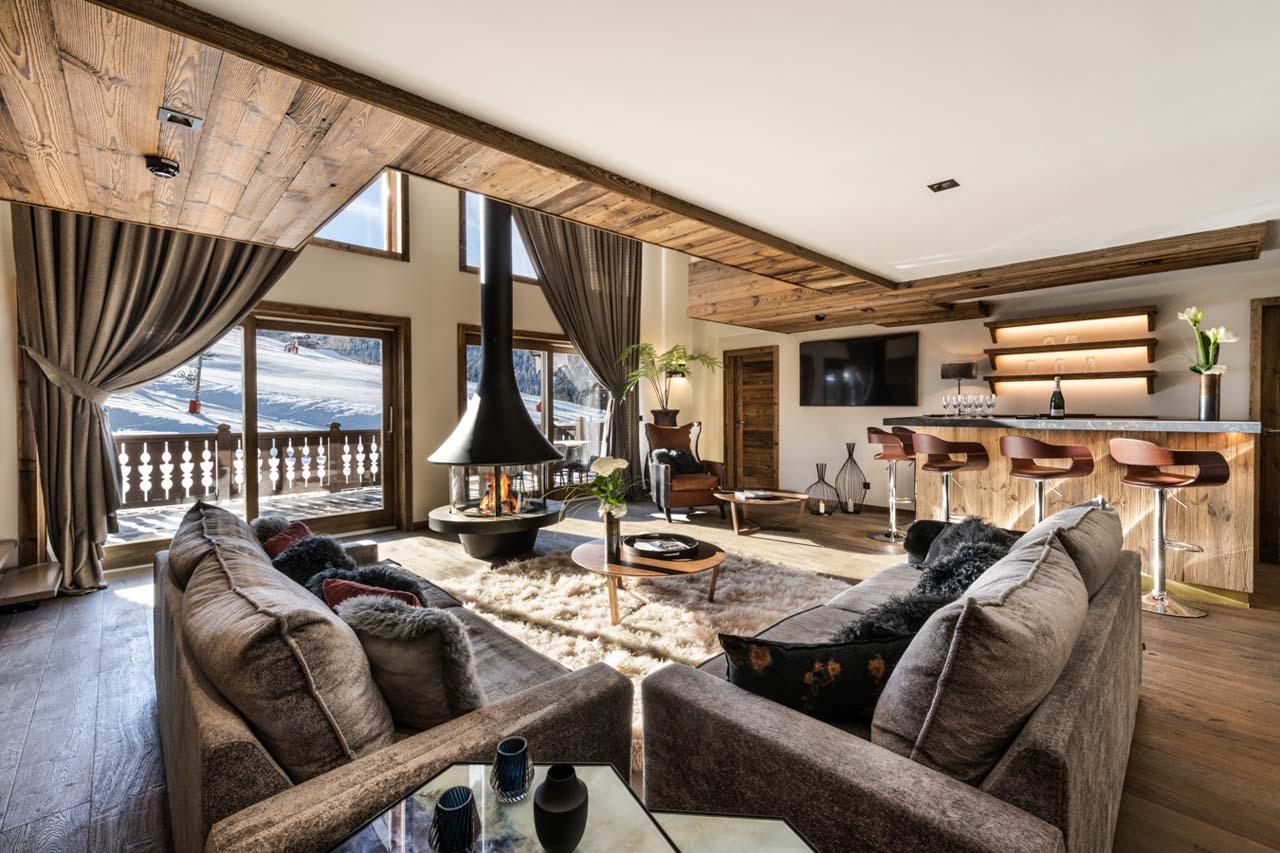 Comfortable sofa area surrounding the fireplace at Apartment Kinabalu in Courchevel 1650