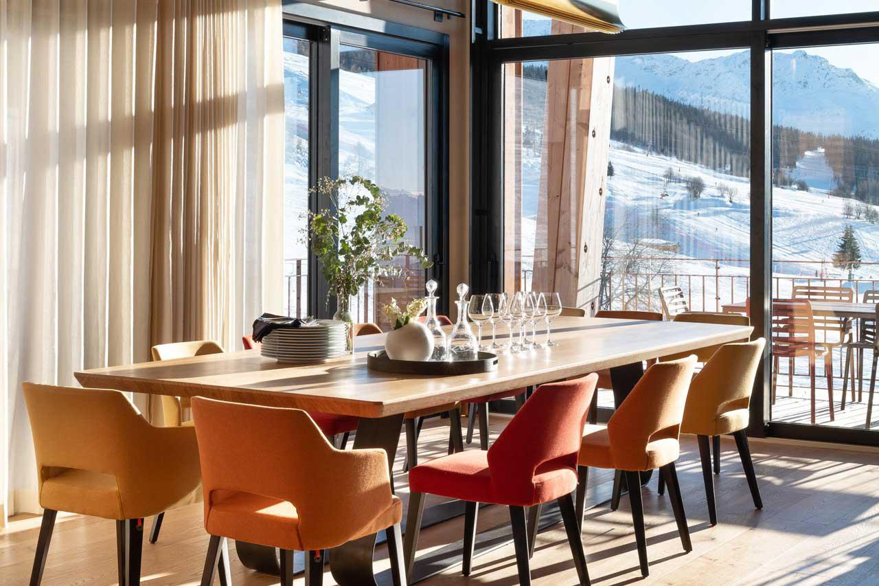 Dining table with exceptional floor-to-ceiling windows at Chalet Arpoza in Les Arcs