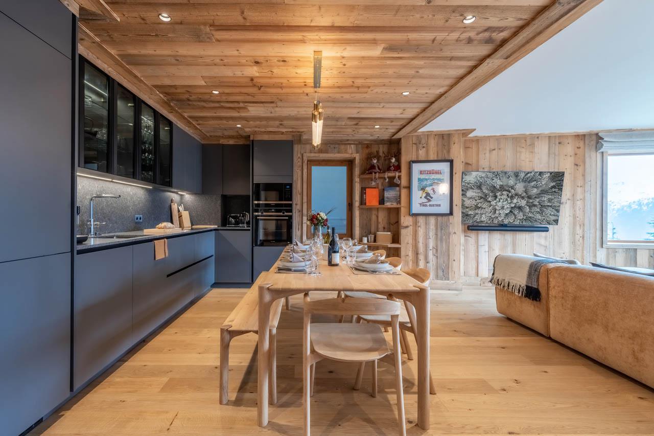 Open-plan living space with kitchen, dining table and lounge at Apartment Manej 4 in Courchevel 1850