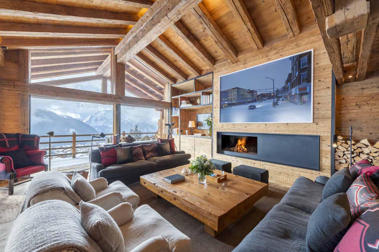 Open living area with sofa space, fireplace and balcony access at Marmotte Penthouse in Verbier