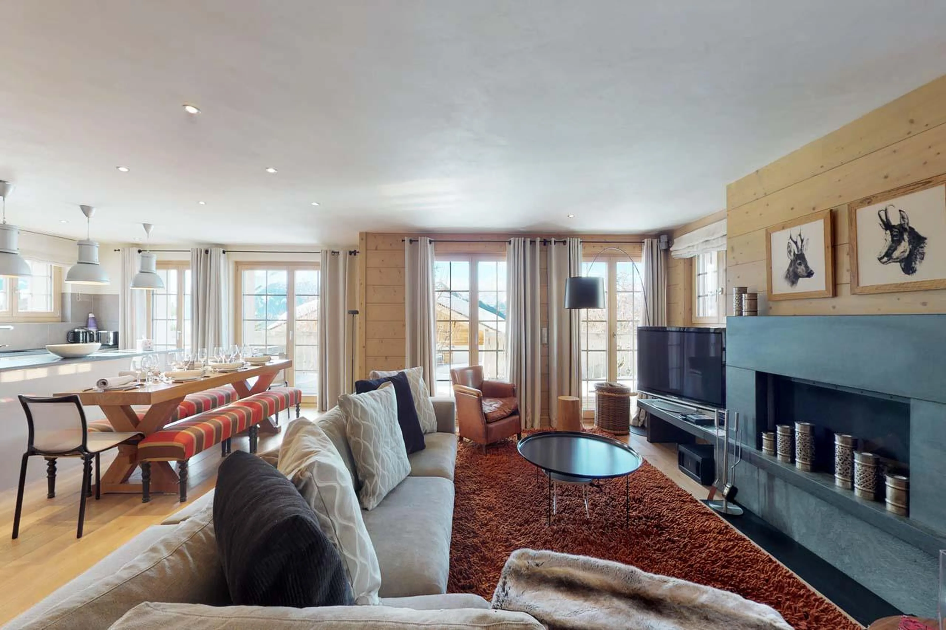 Open-plan living area with French doors opening out onto terrace at Chalet Albert-Luc in Verbier