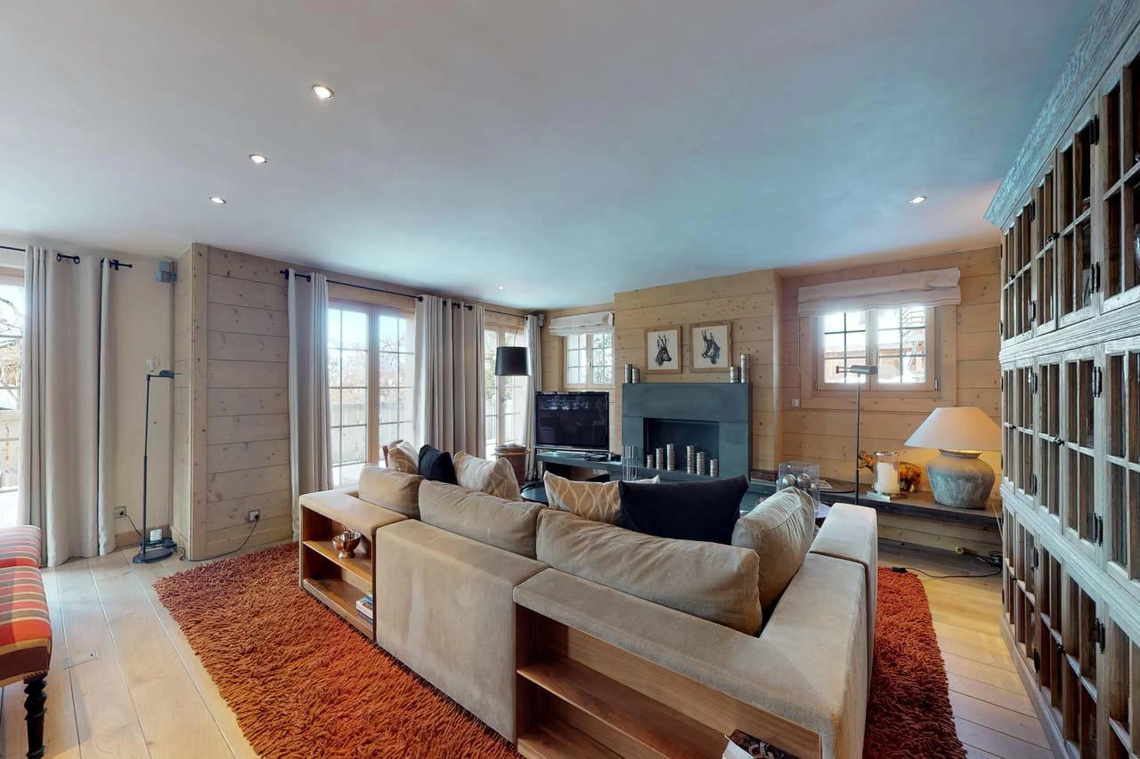 L-shaped sofa surrounding the wood-burning fireplace at Chalet Albert-Luc in Verbier