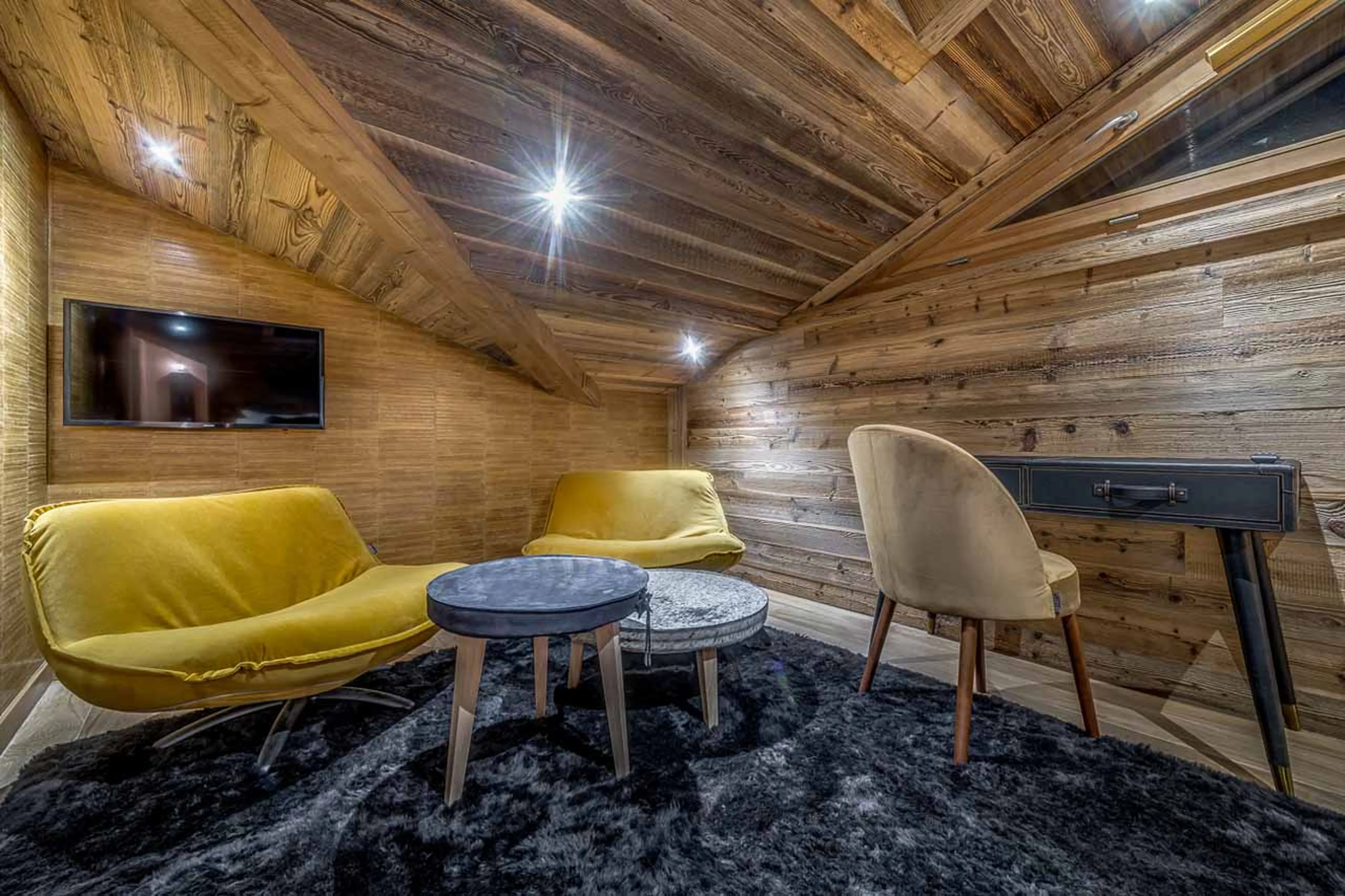 TV and armchairs in bedroom one of Apartment Ben Nevis in Les Gets