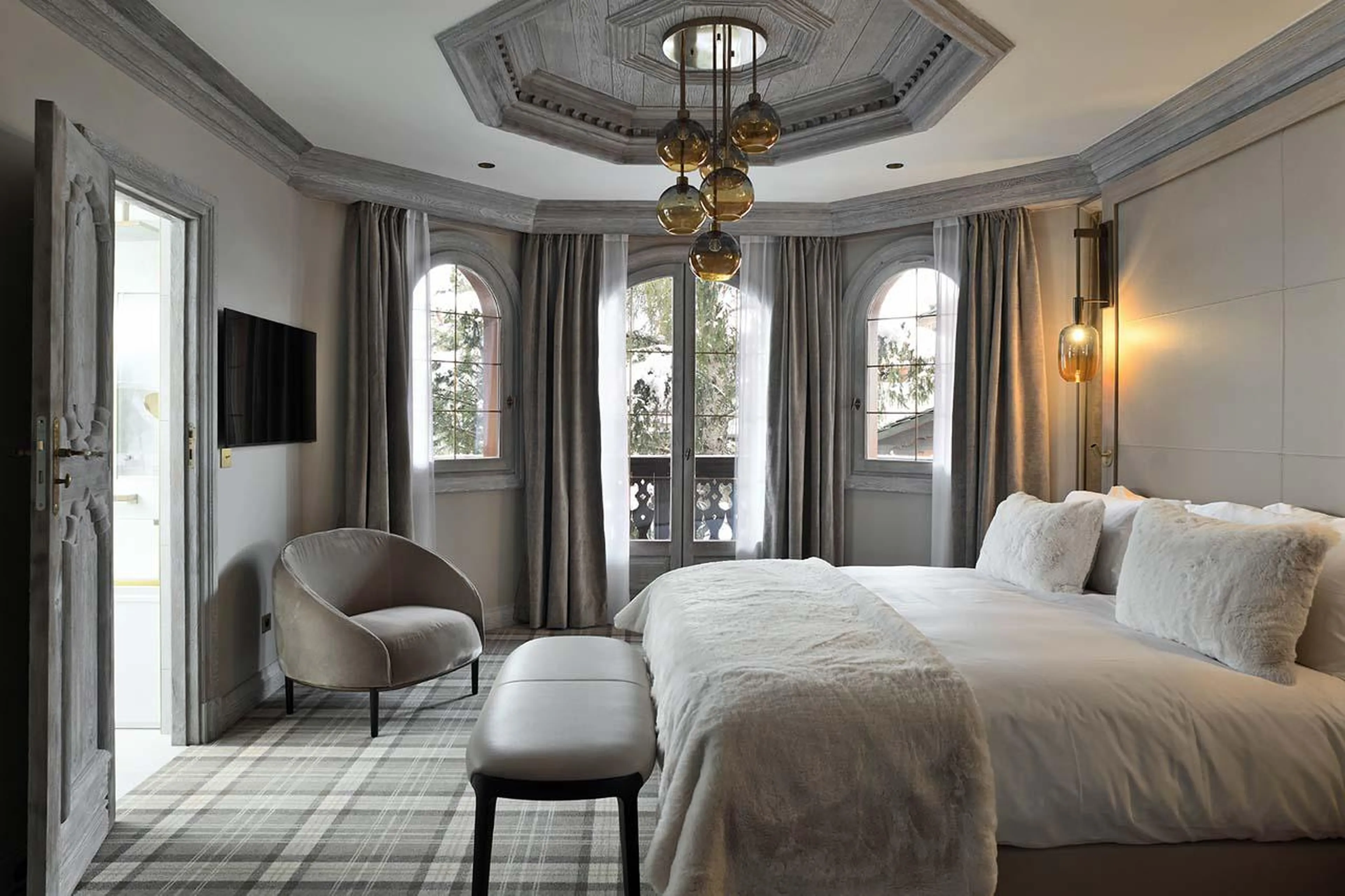 Master bedroom with balcony access and en-suite bathroom at Apartment Chanrossa in Courchevel 1850