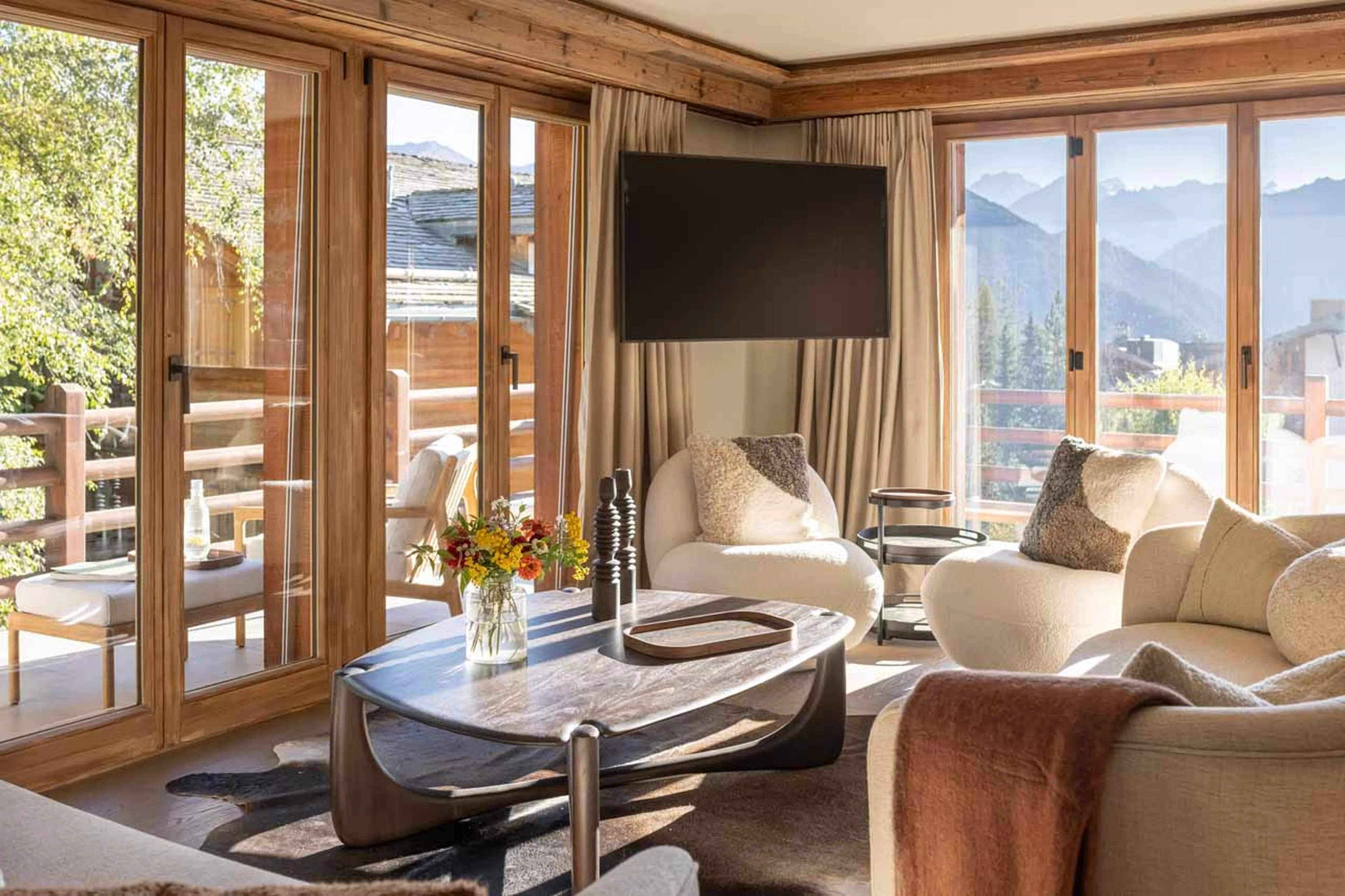Living area with TV and balcony access at Apartment Corbettaz in Verbier