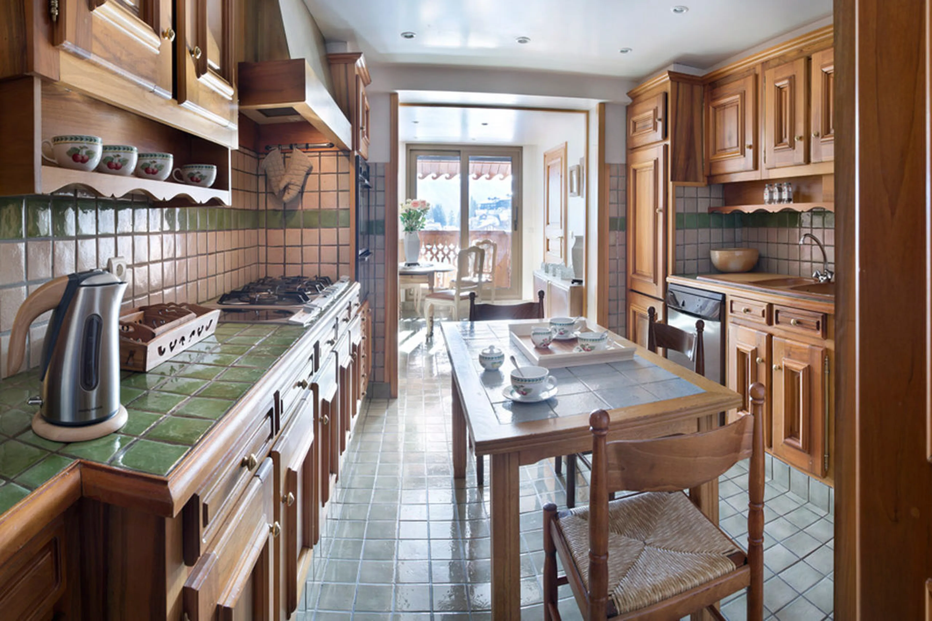 Fully equipped kitchen with breakfast area and balcony access in Apartment Le Refuge, Courchevel 185