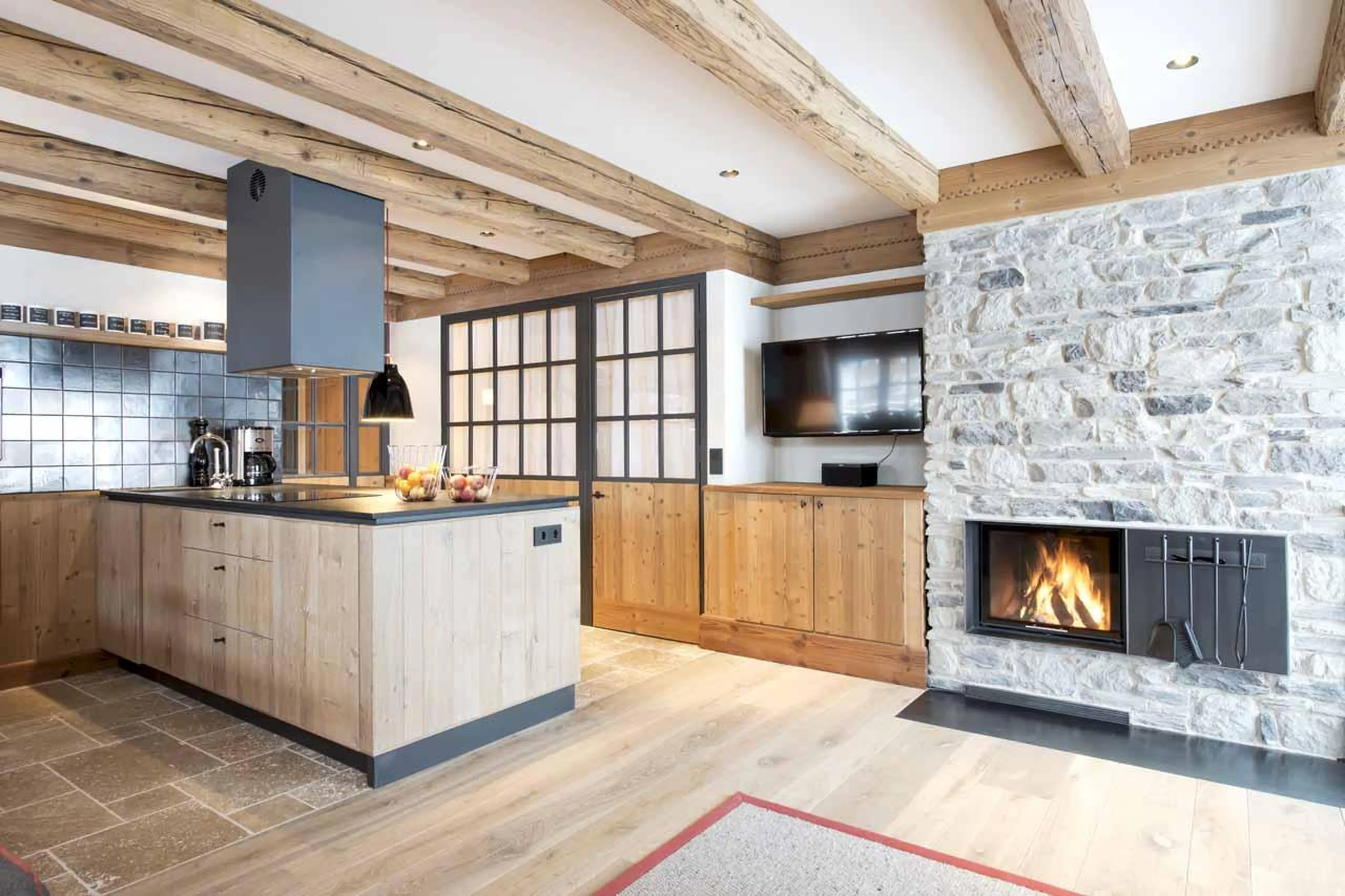 Kitchen with large island and fireplace in Apartment Lech I, Lech