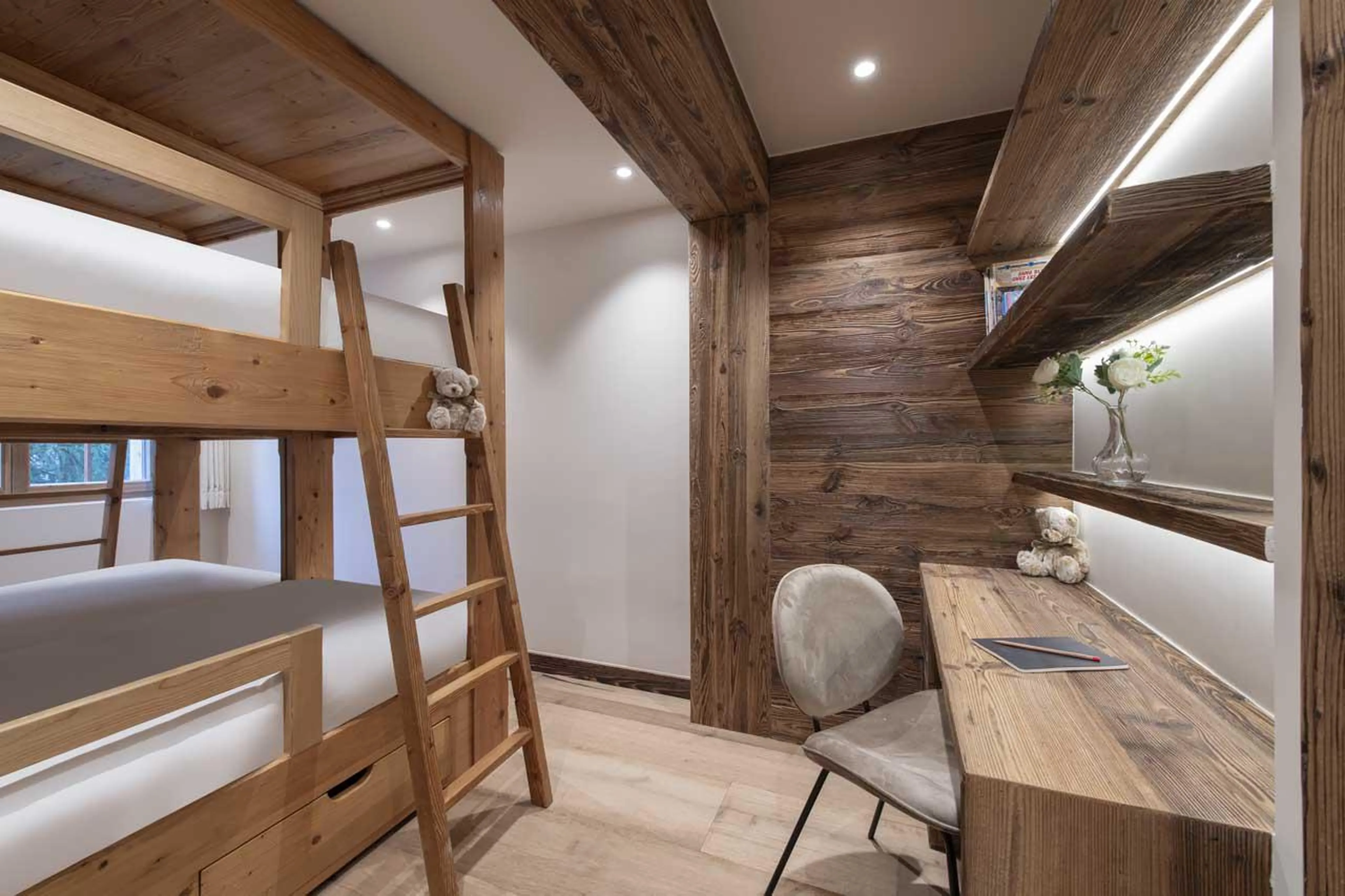 Twin bunk bedroom with desk area and en-suite bathroom at Apartment Lussy in Verbier