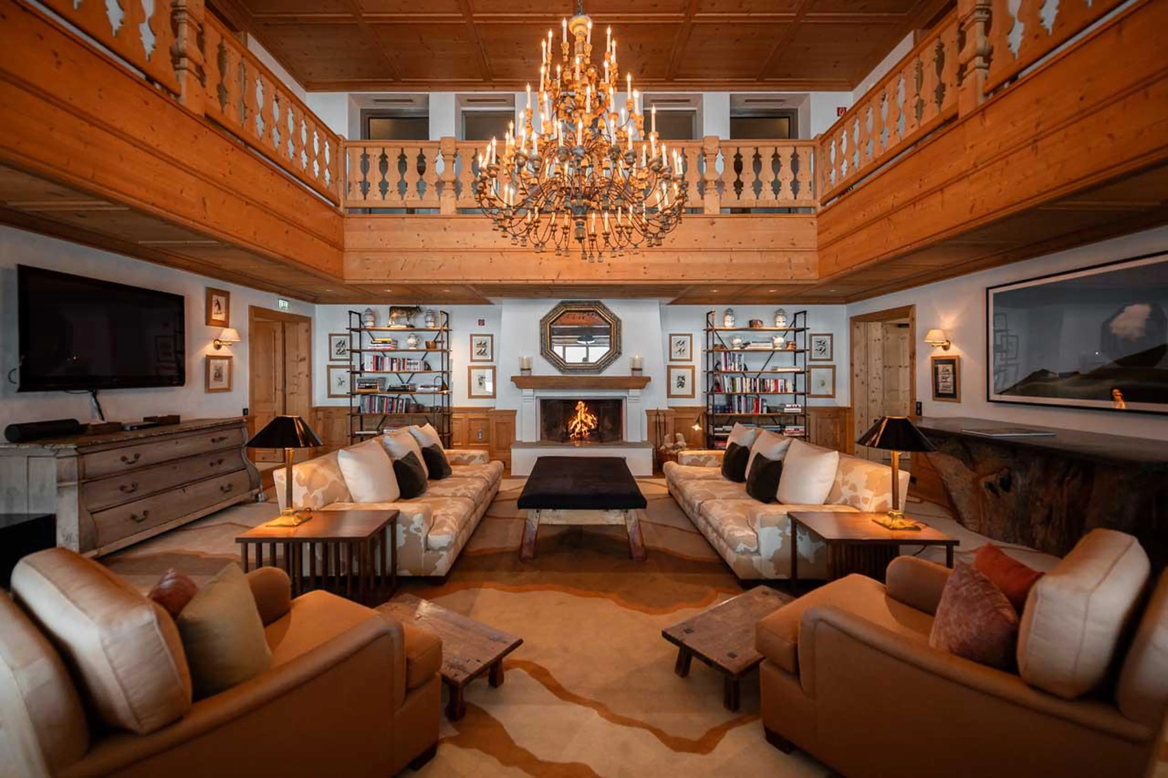 Double-height living room with open fireplace at Aurelio Club Chalet in Lech