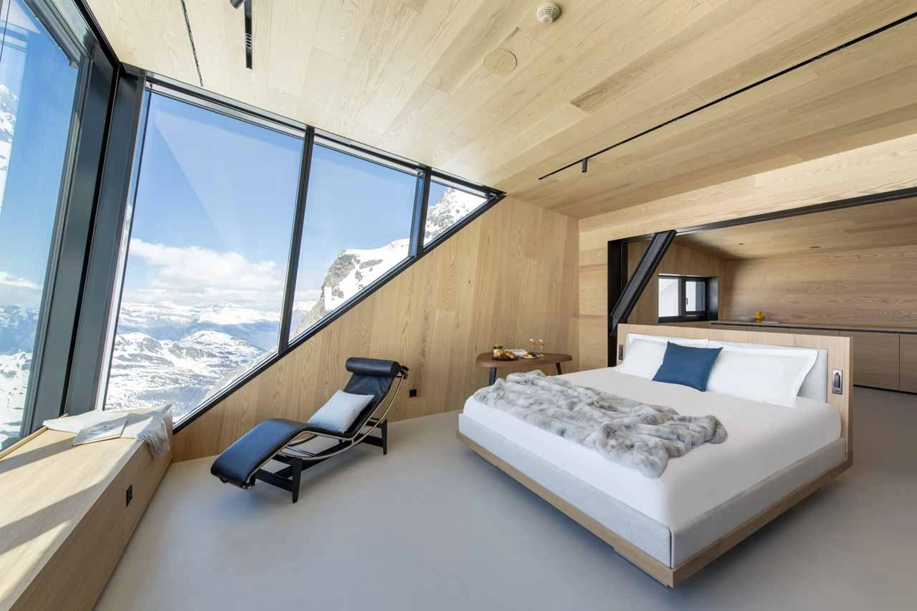 Spacious double bedroom with lounger in Cabane Tortin, Verbier