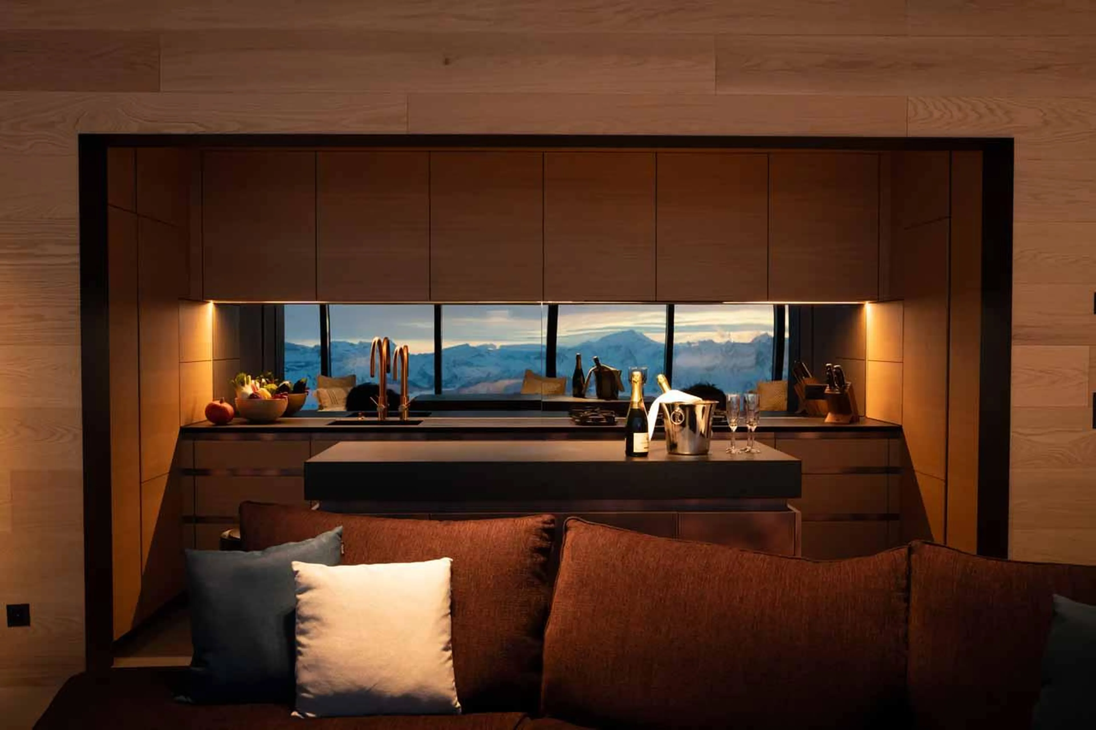 Kitchen and sofa in evening light in Cabane Tortin, Verbier