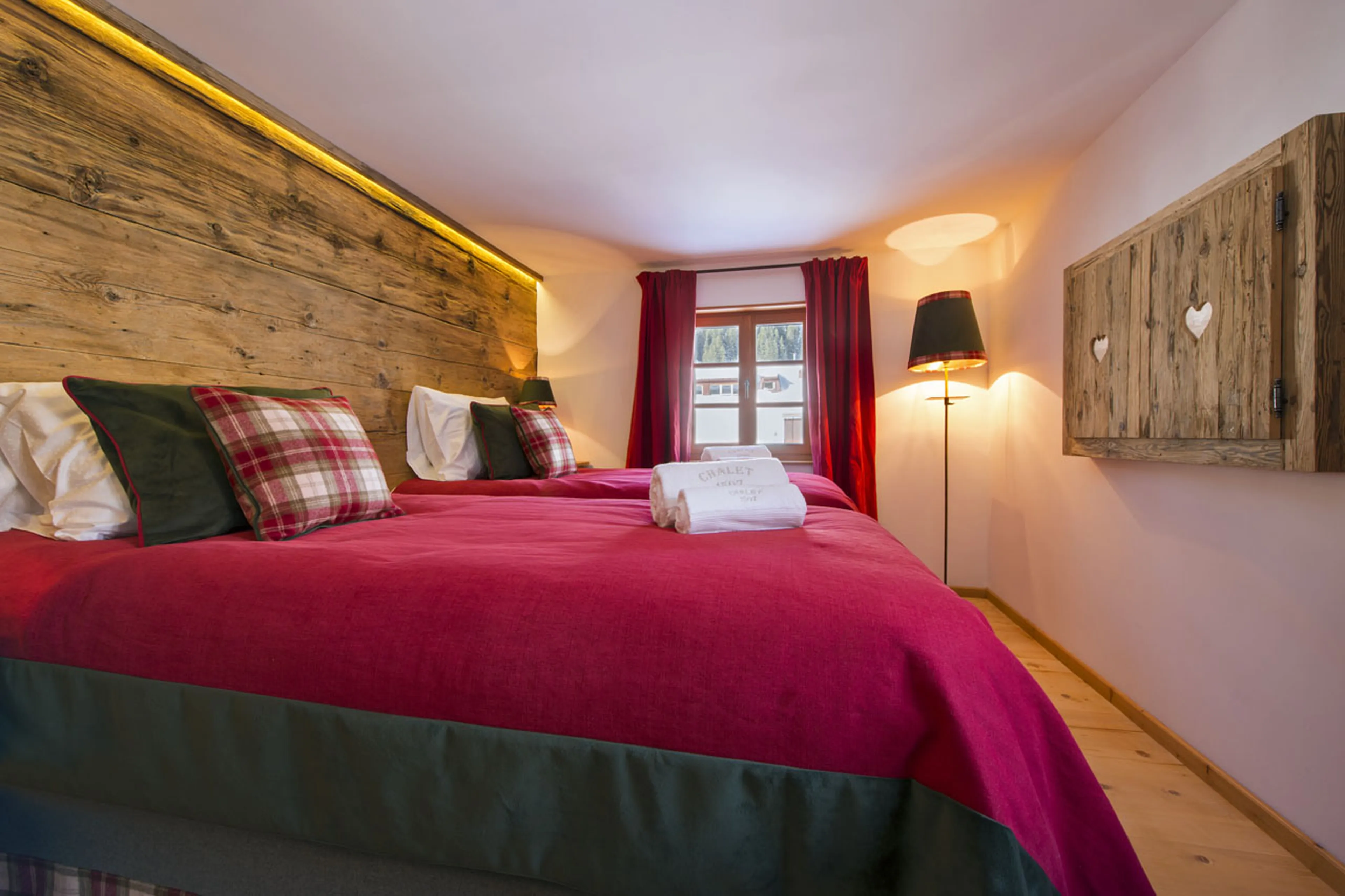 Lech’s Chalet 1597 has a double/twin bedroom with striking burgundy textiles