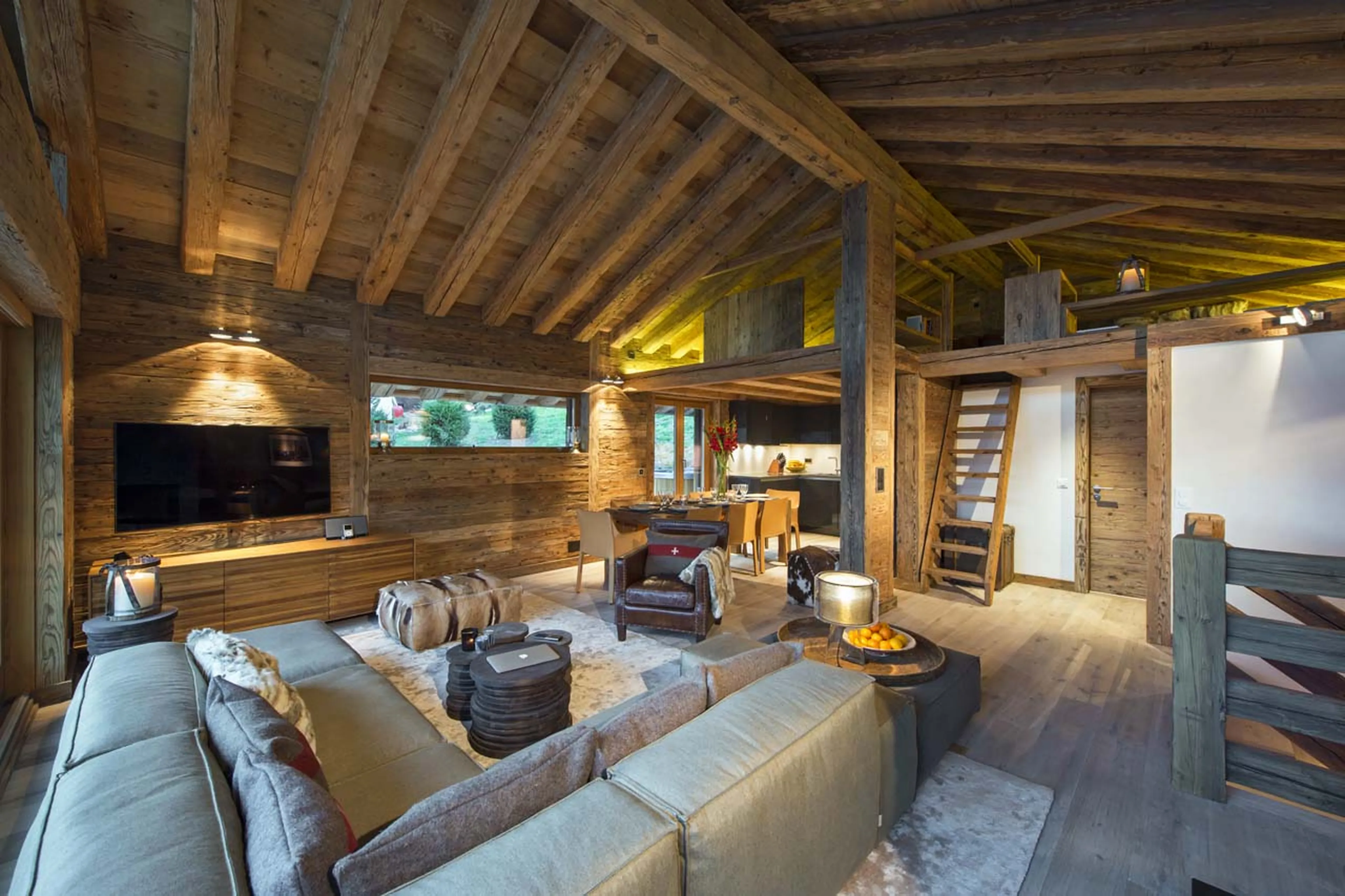 Living room with stairs up to mezzanine living area in Chalet Alpine Roc in Verbier