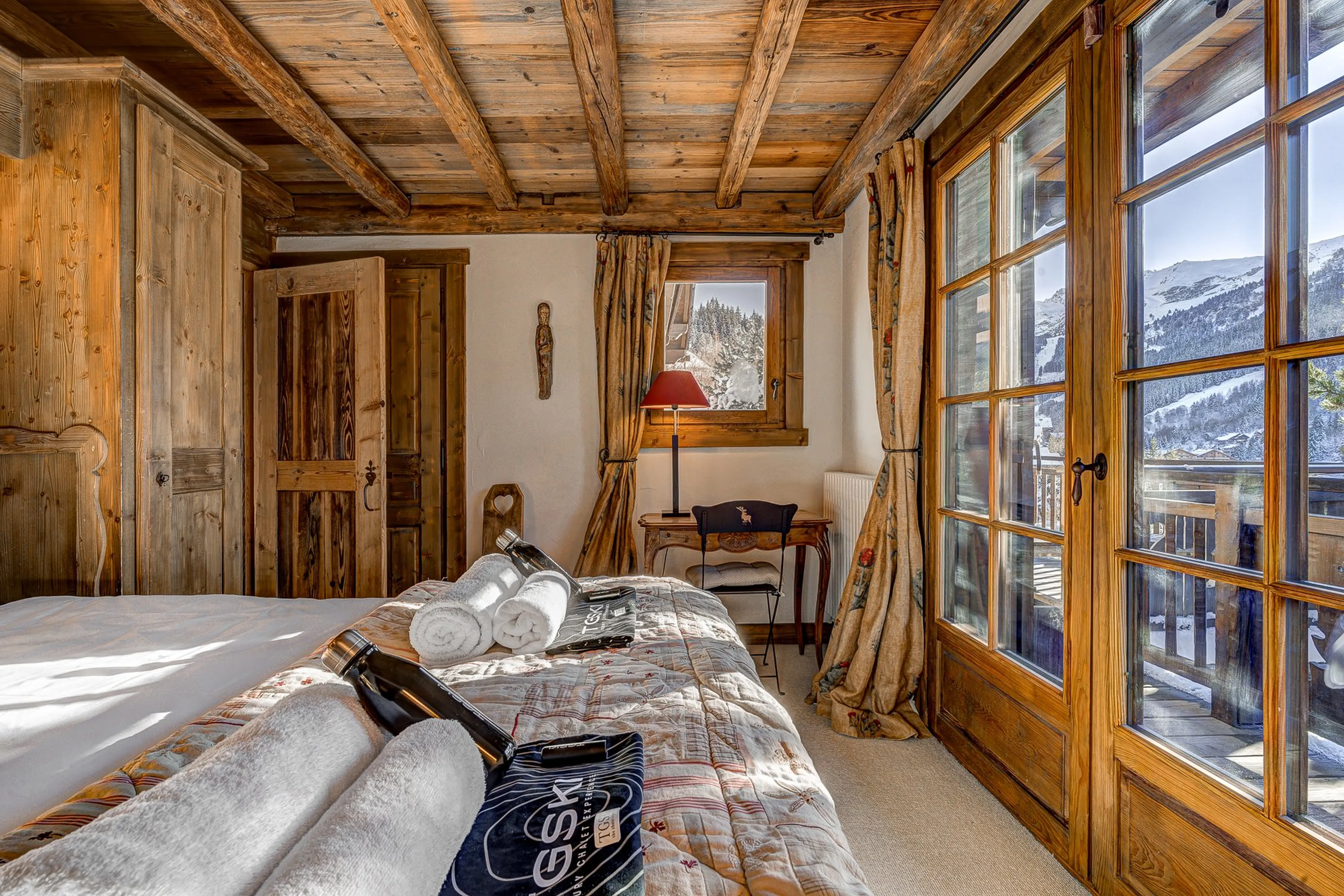 Bedroom one with terrace access at Chalet Amarena in Meribel