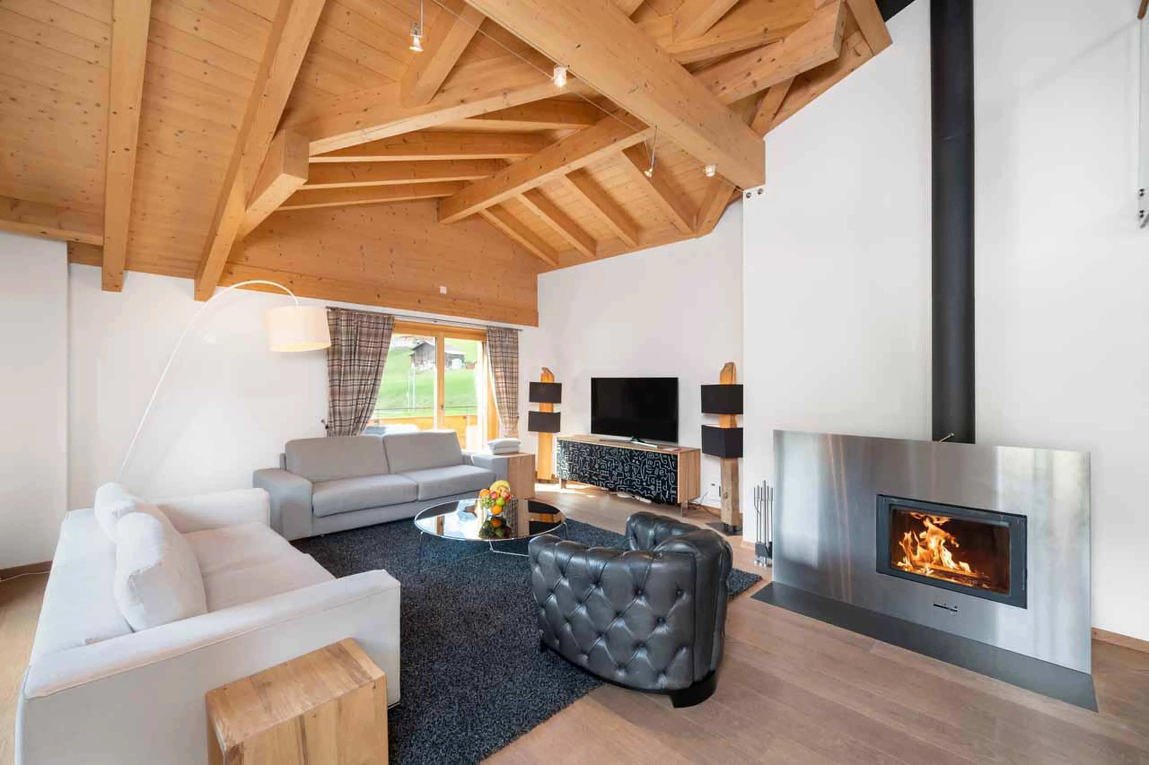 Open-plan living space with fireplace at Apartment Antara in Grindelwald