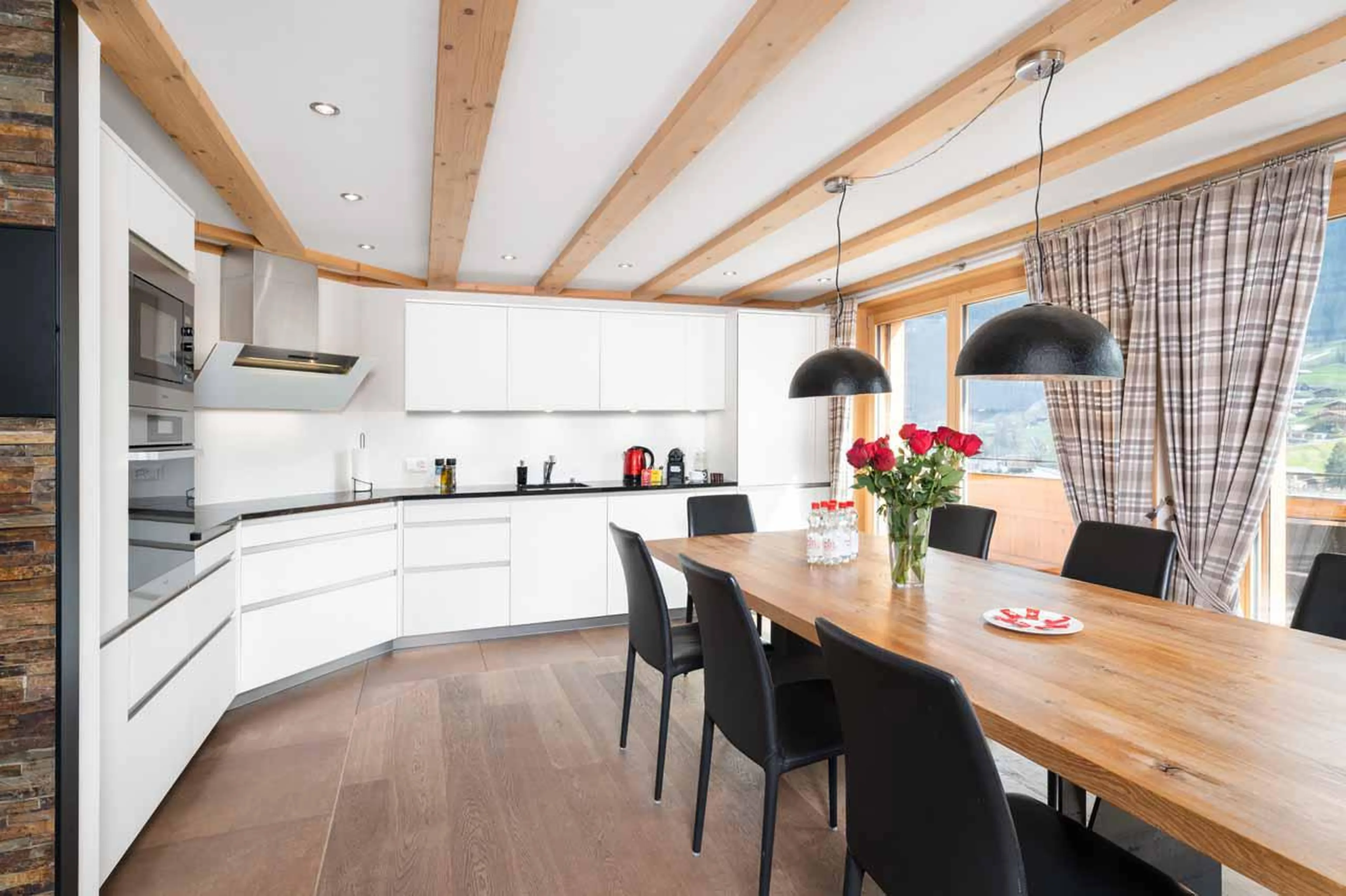 Open kitchen area with dining table at Apartment Antara in Grindelwald
