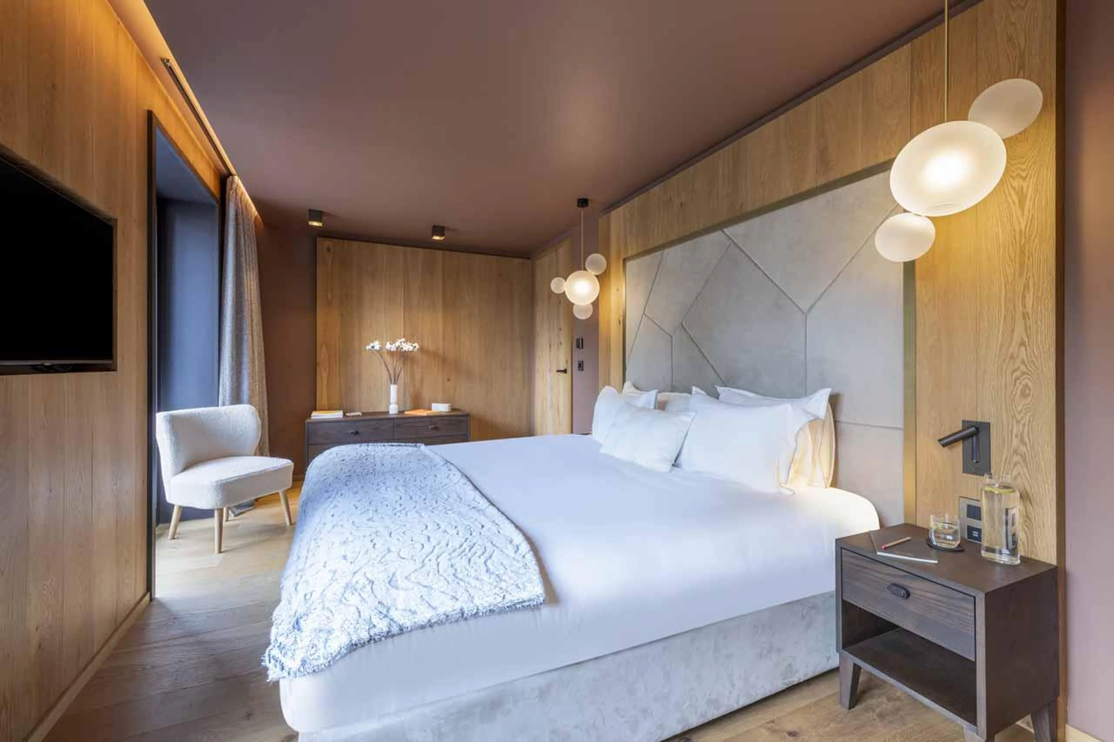 Double bedroom with TV and chair in Chalet Ascension, Courchevel 1650