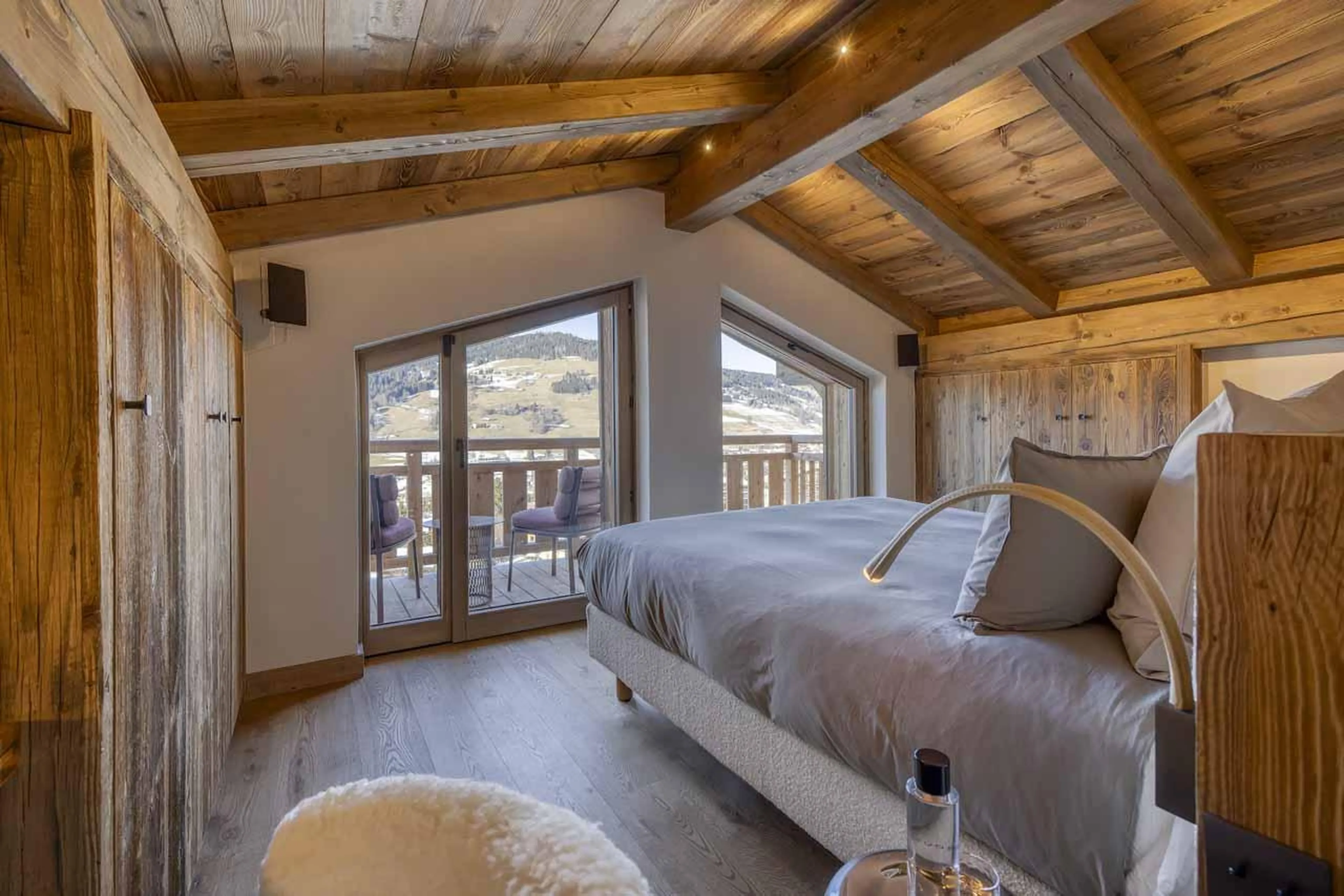 Double bed in front of vaulted windows in Chalet Aspen, Megeve