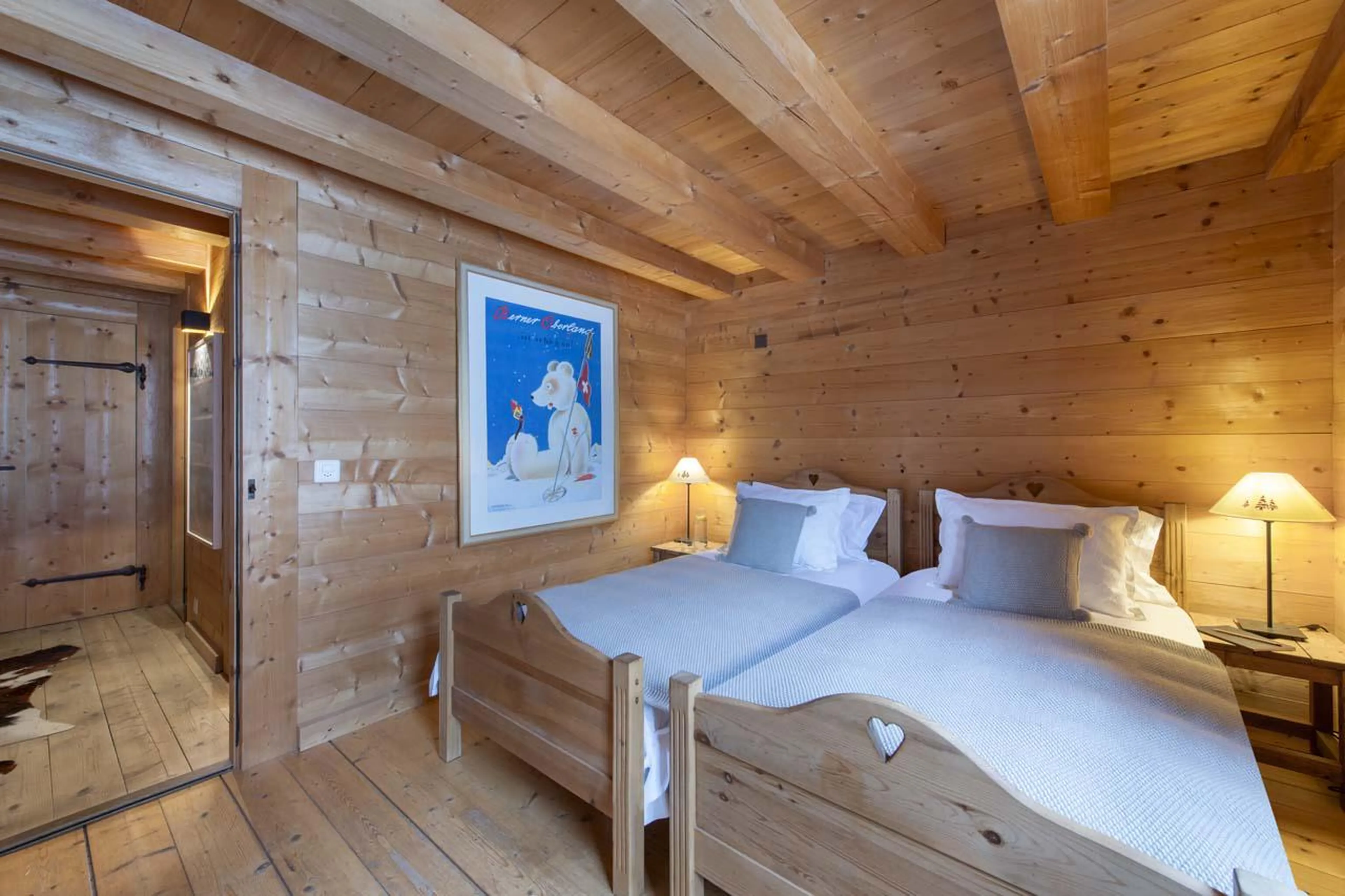 Twin bedroom with wooden interior and ambient lighting at Chalet Bavaria in Verbier