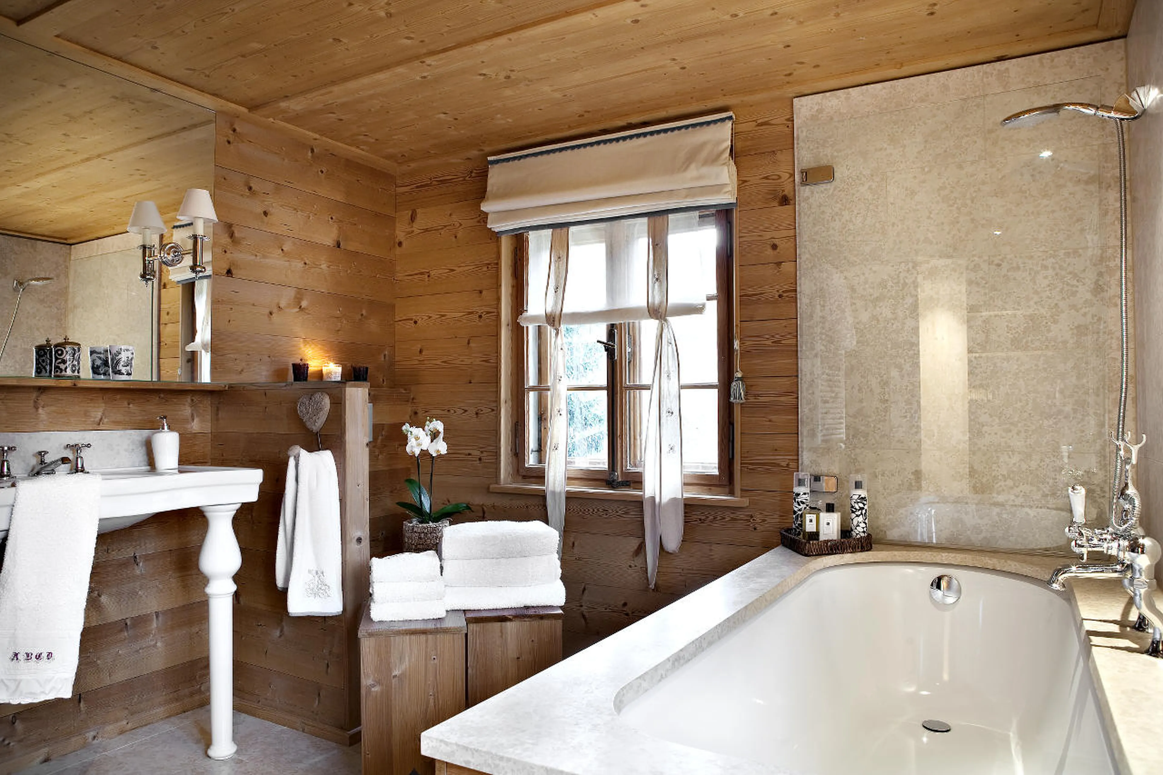 En-suite bathroom with bath and shower in Chalet Bear in Klosters