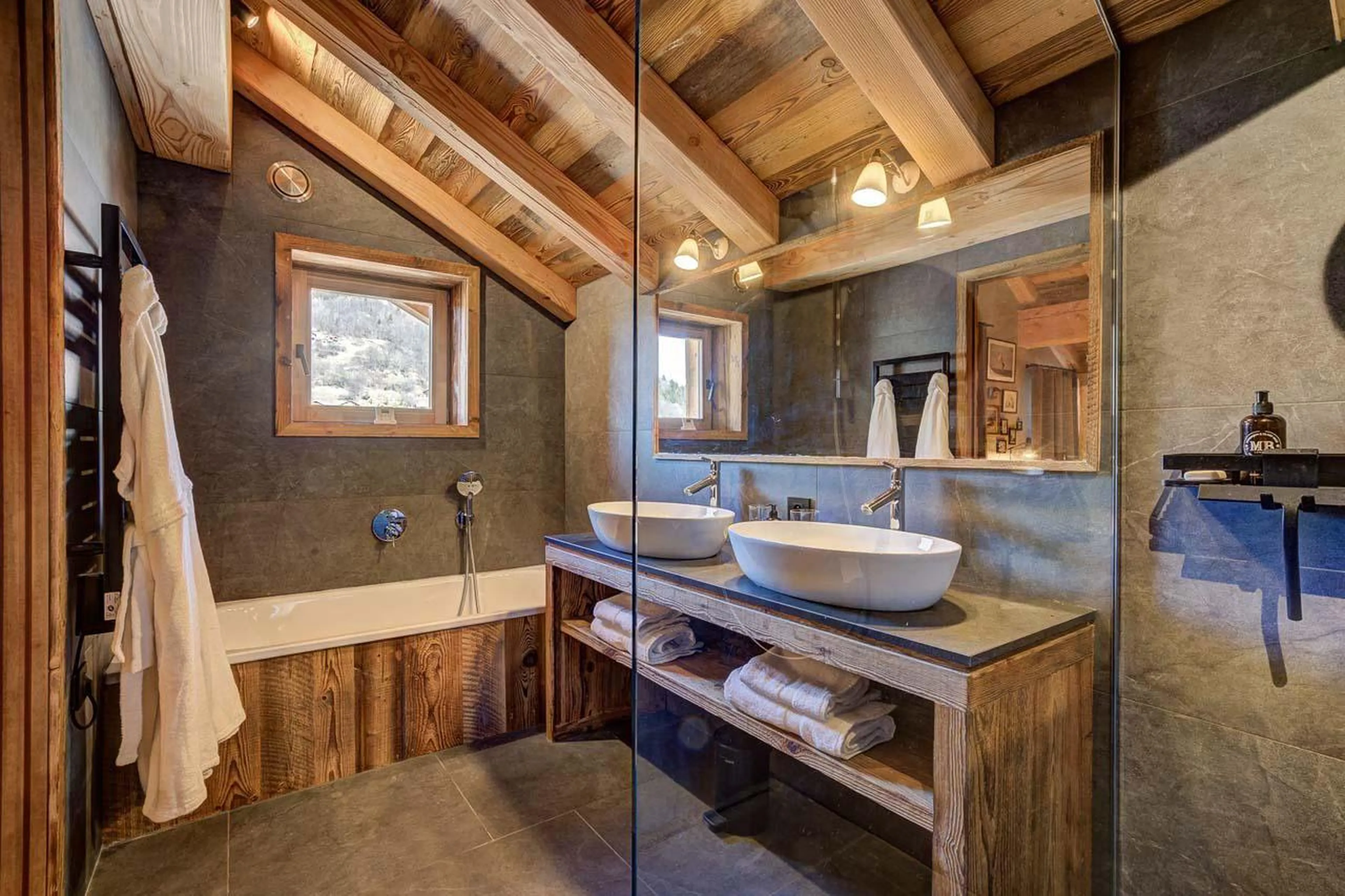 En-suite bathroom with bath and shower at Chalet Bergeronnette in Meribel