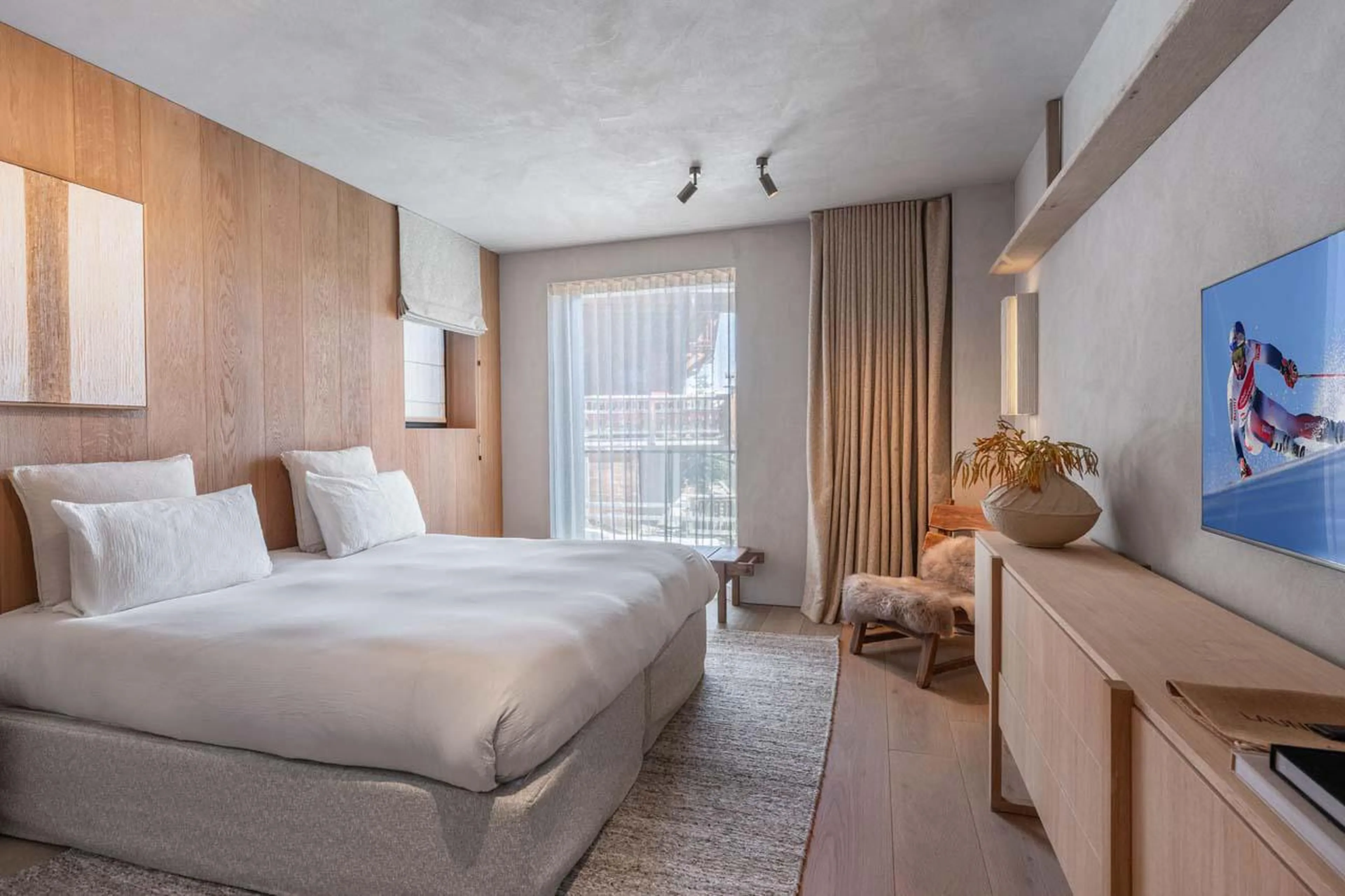 Double bedroom with balcony access and en-suite bathroom at Chalet Black Lodge in Courchevel 1850