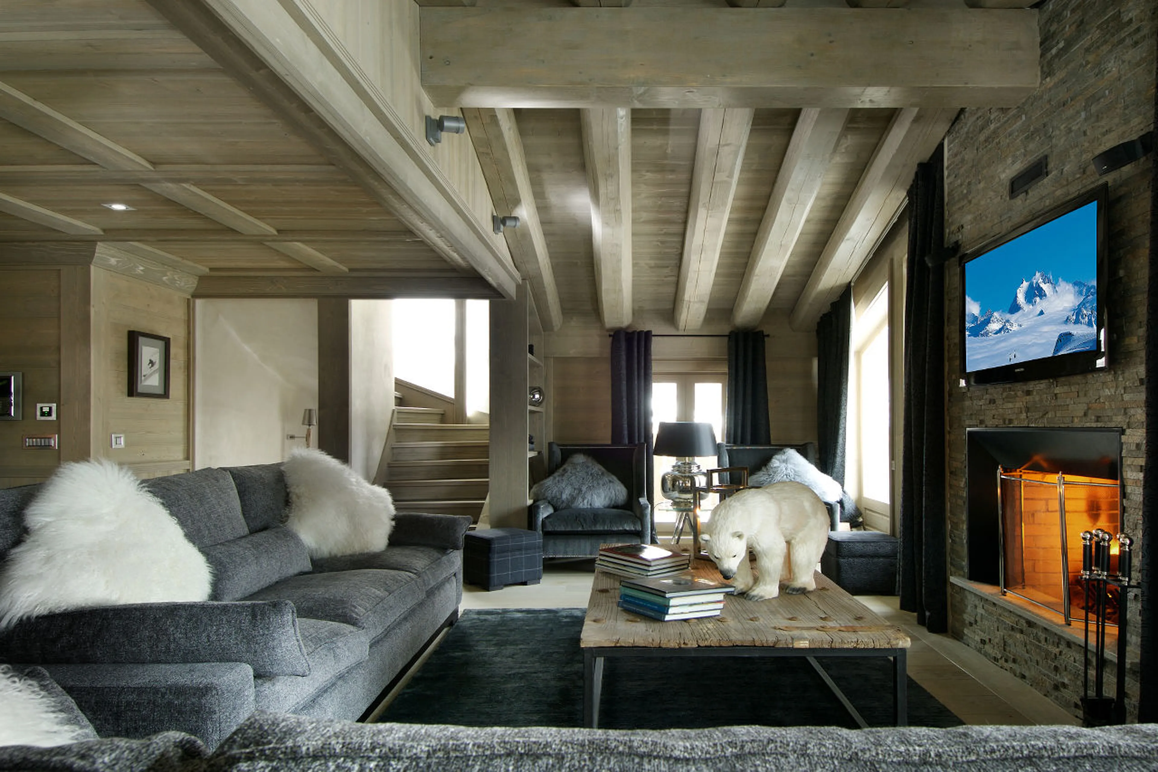 Living room with central fireplace in Chalet Black Pearl in Val d’Isere