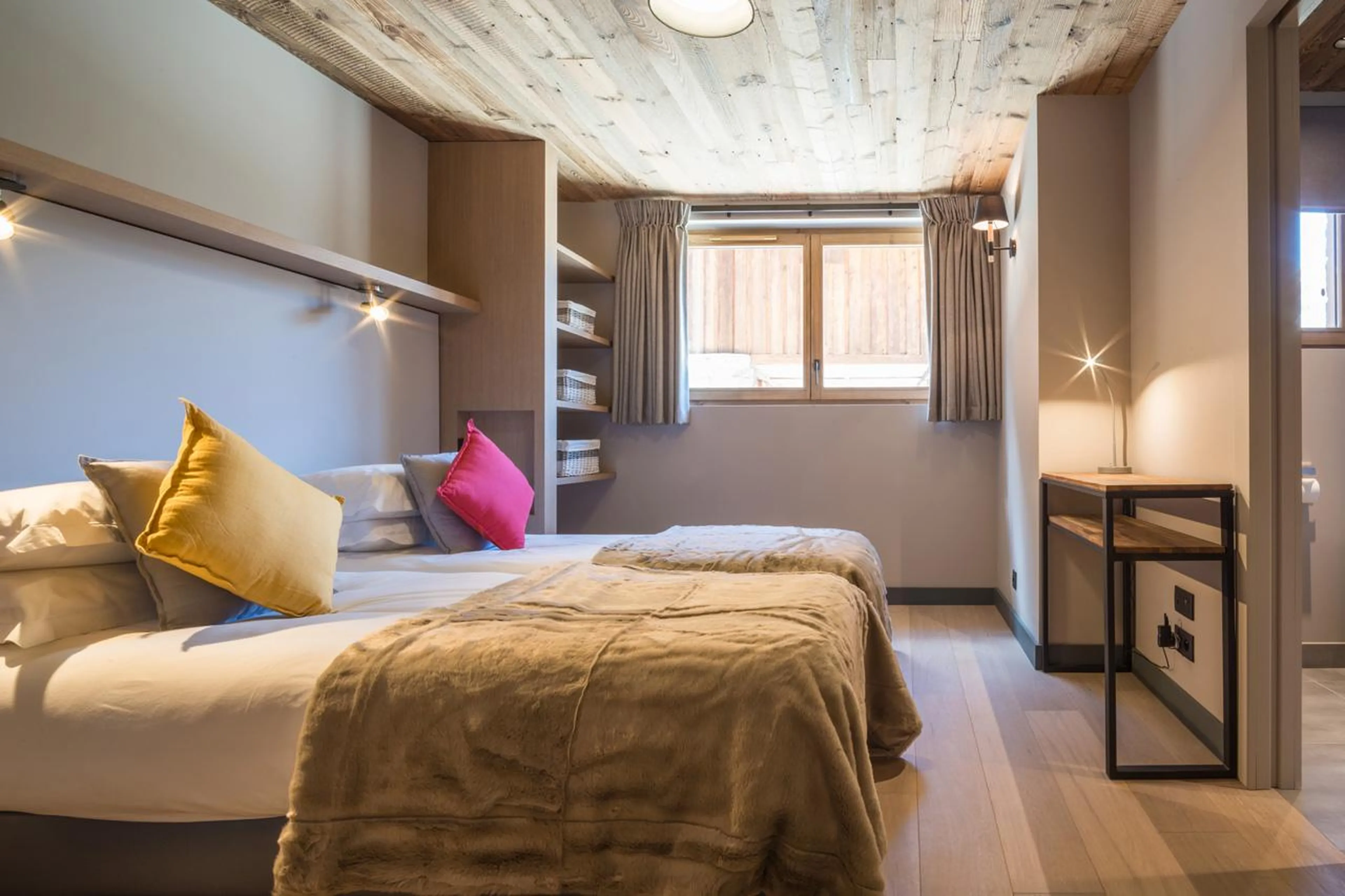 Twin bedroom with shelves, window and side table in Chalet Caro, Meribel