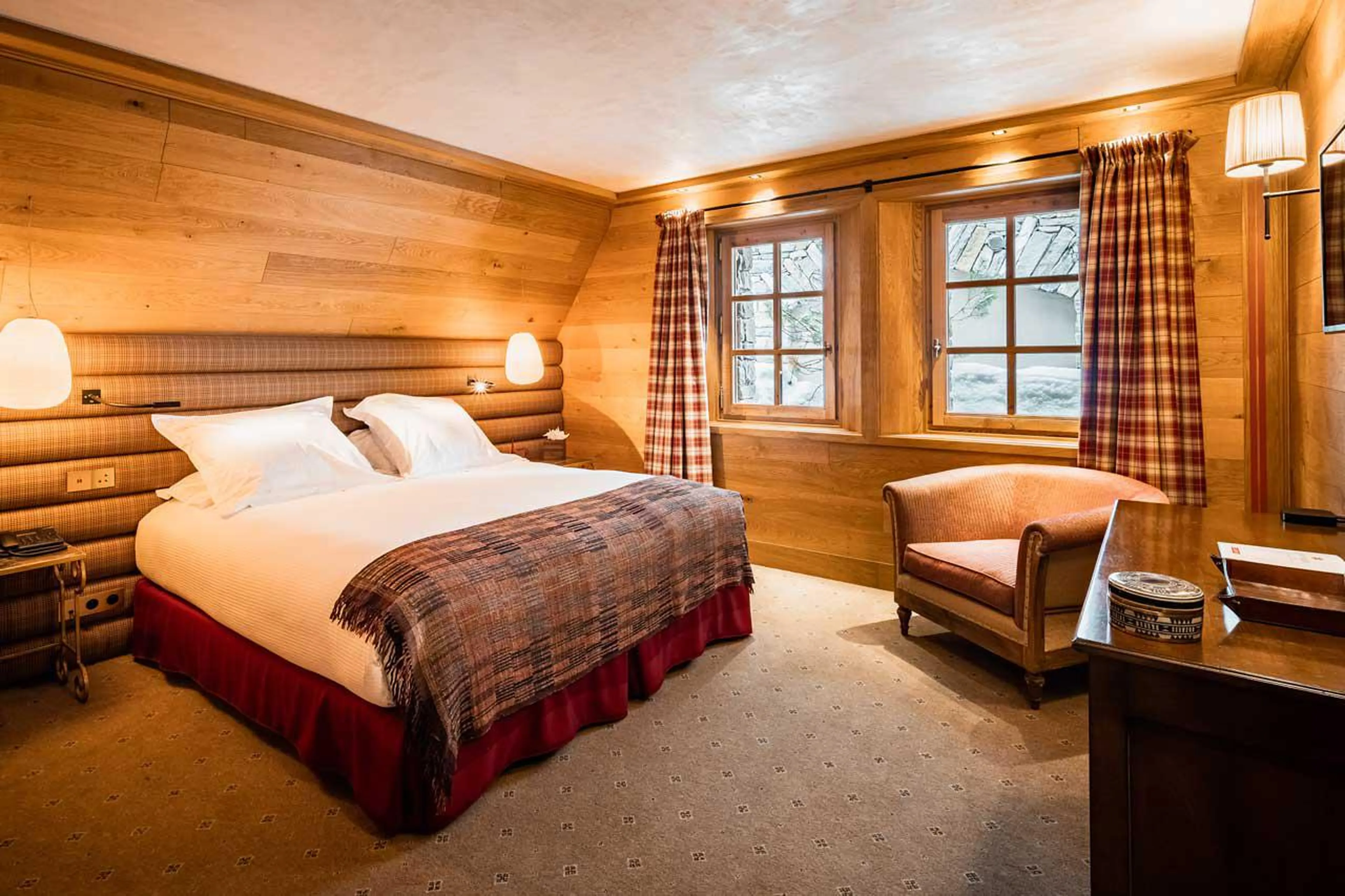 Comfortable double bed and view on fir trees in Chalet Chene in Val d’ Isere