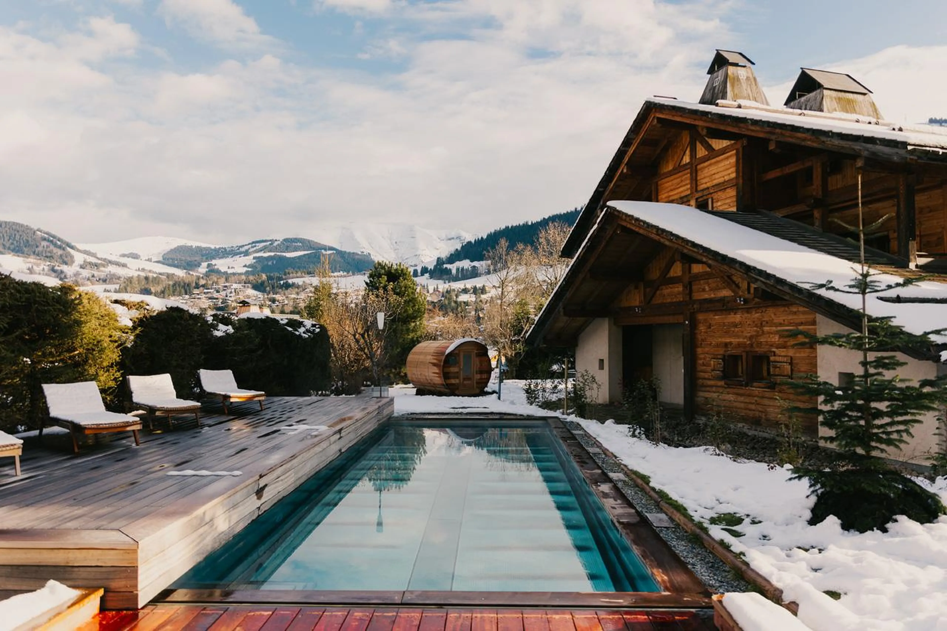 Outdoor swimming pool with loungers on terrace in Chalet Clovis, Megeve