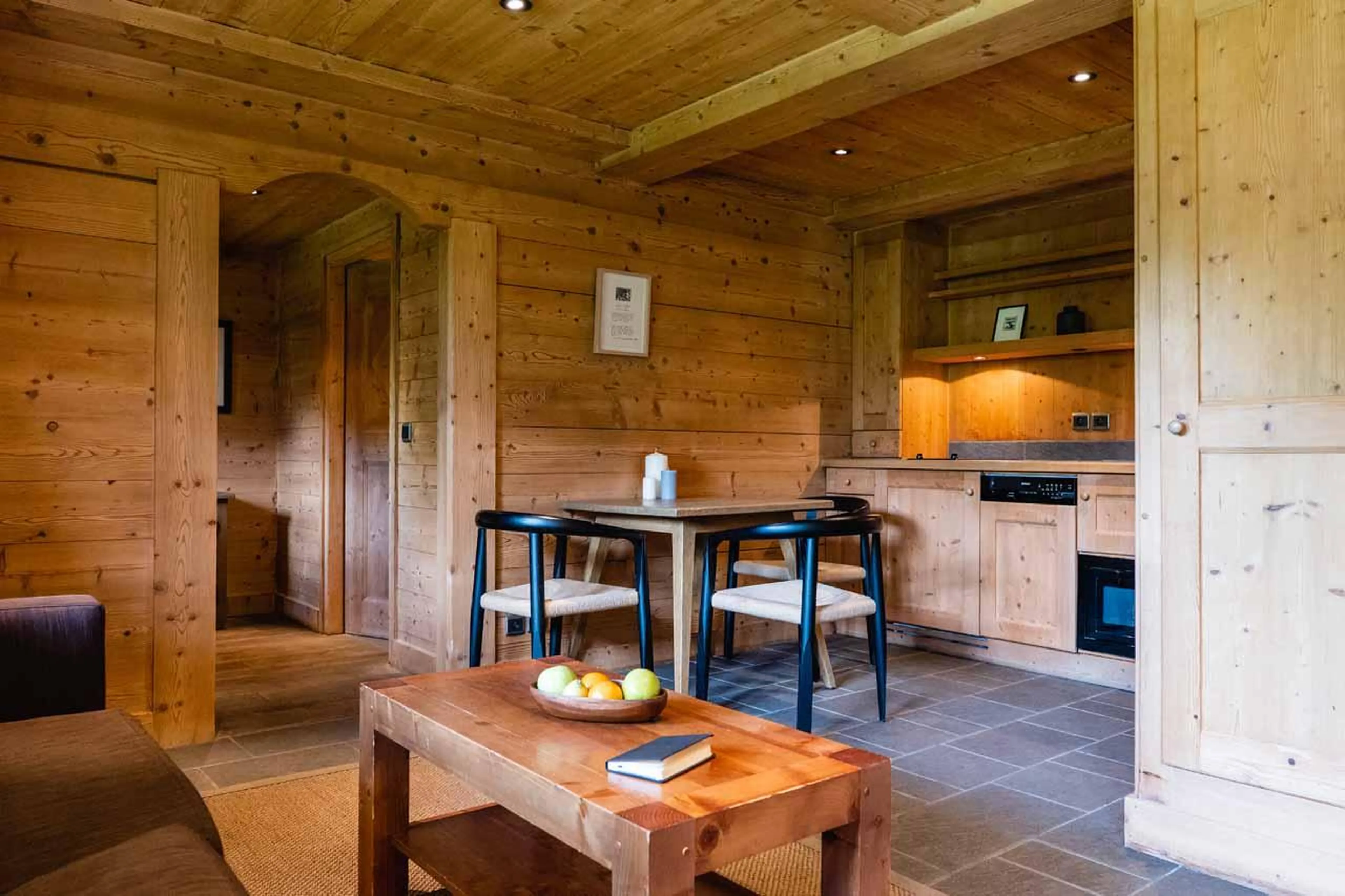 Sofa, coffee table, dining table and kitchenette in Chalet Clovis, Megeve