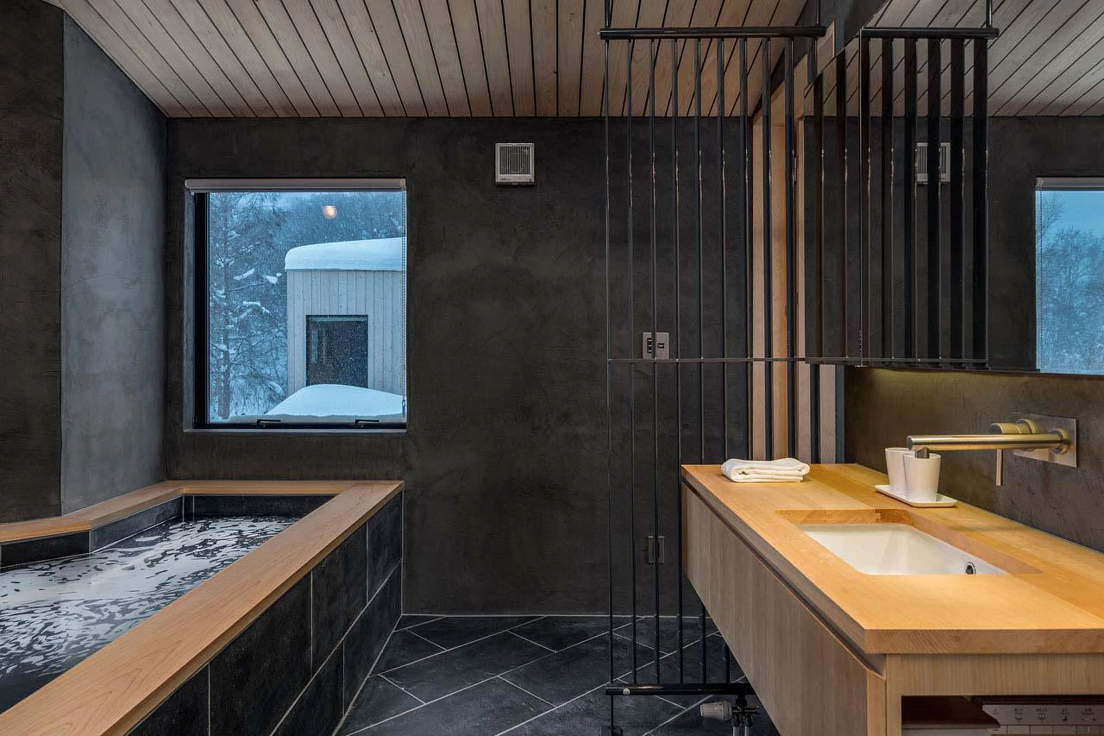 Modern bathroom with Japanese-style soaking tub at Chalet Foxwood B in Niseko