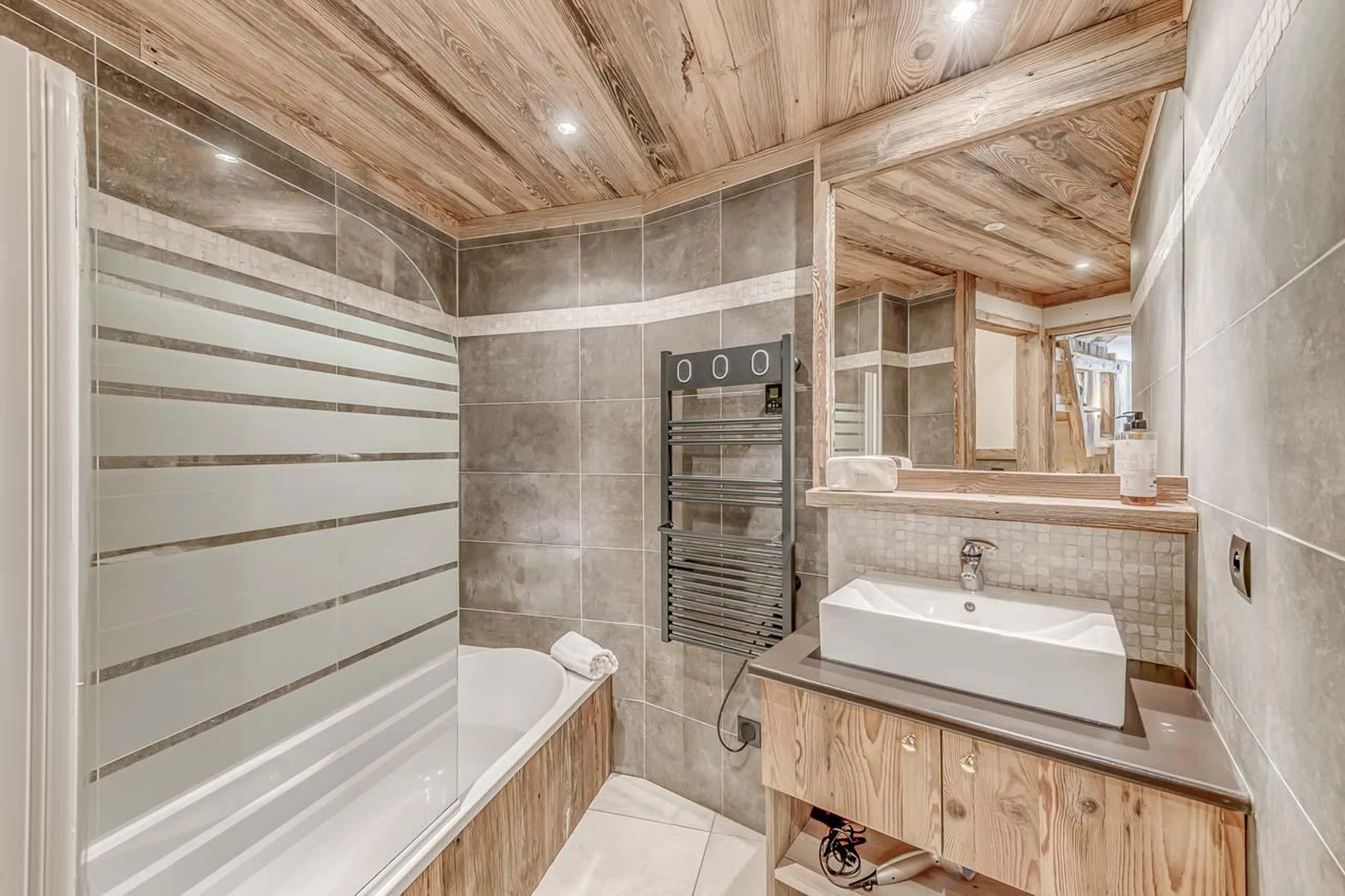 Luxurious en suite bathroom with bathtub and towel warmer at Chalet Ganga in Tignes