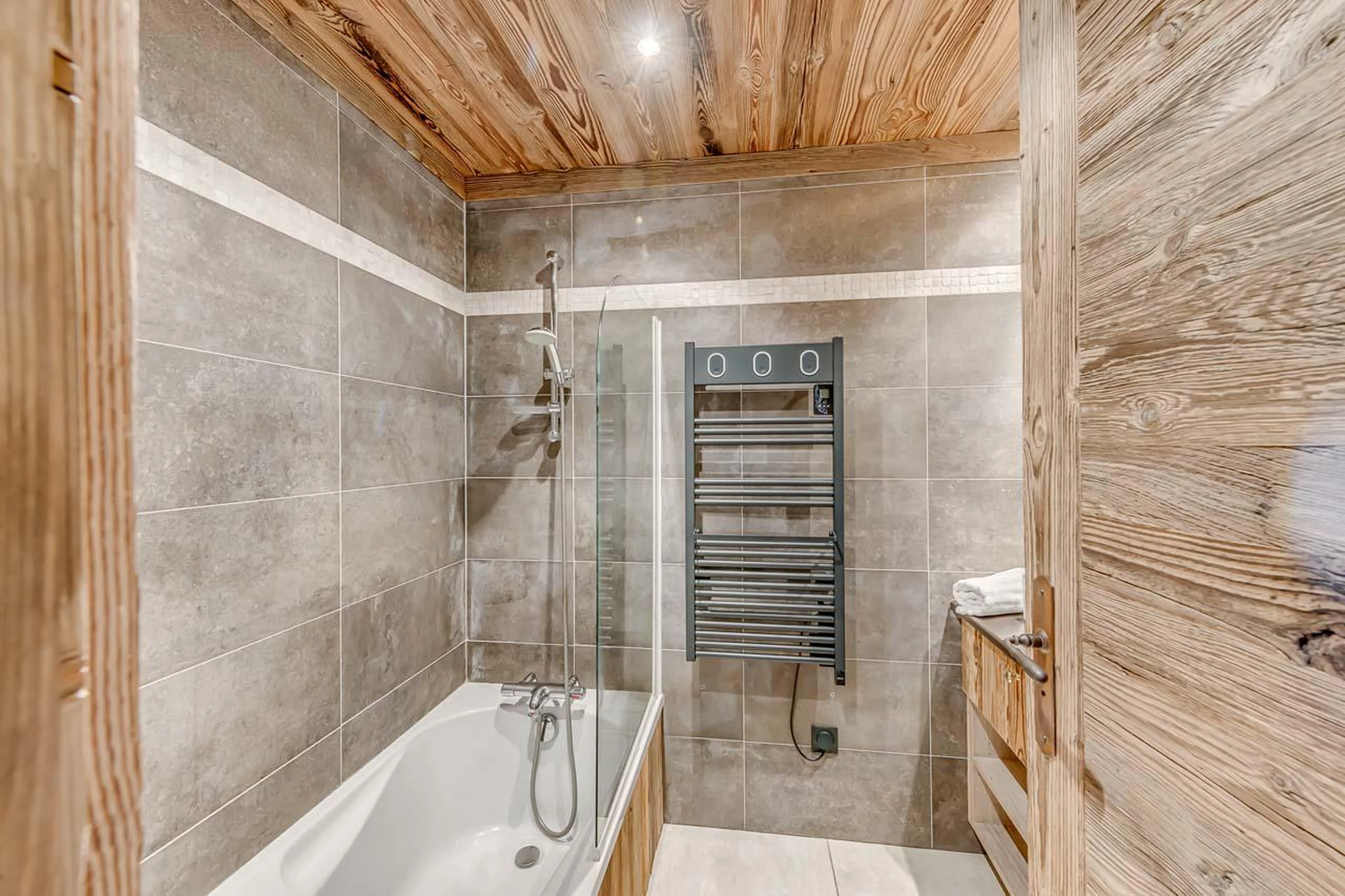 En suite bathroom with bathtub and towel warmer at Chalet Ganga in Tignes