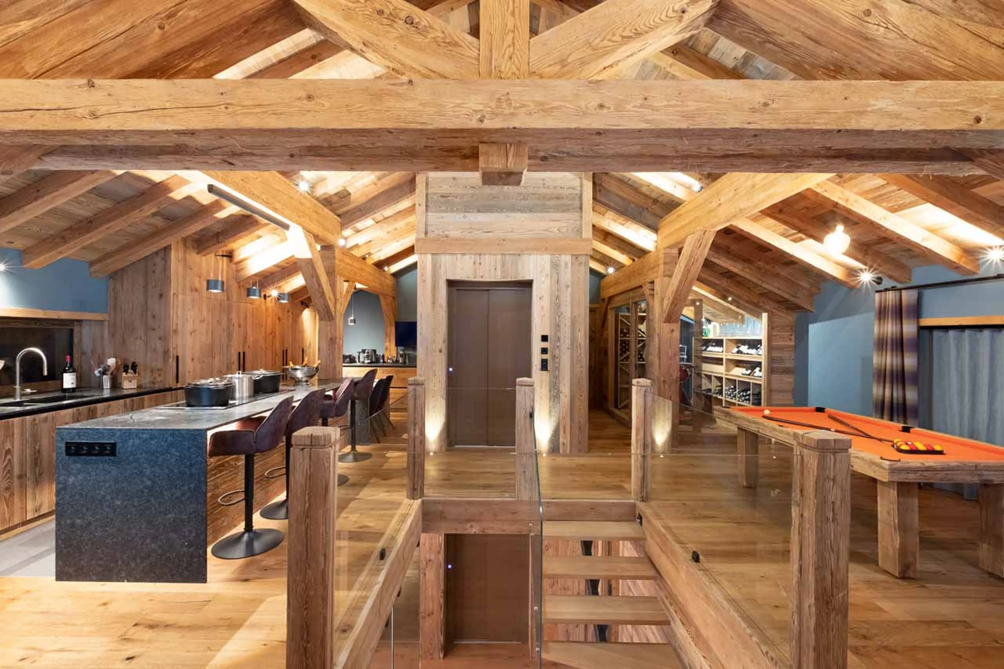 Living area with kitchen, staircase, lift and pool table in Chalet Grande Kalinka, Meribel
