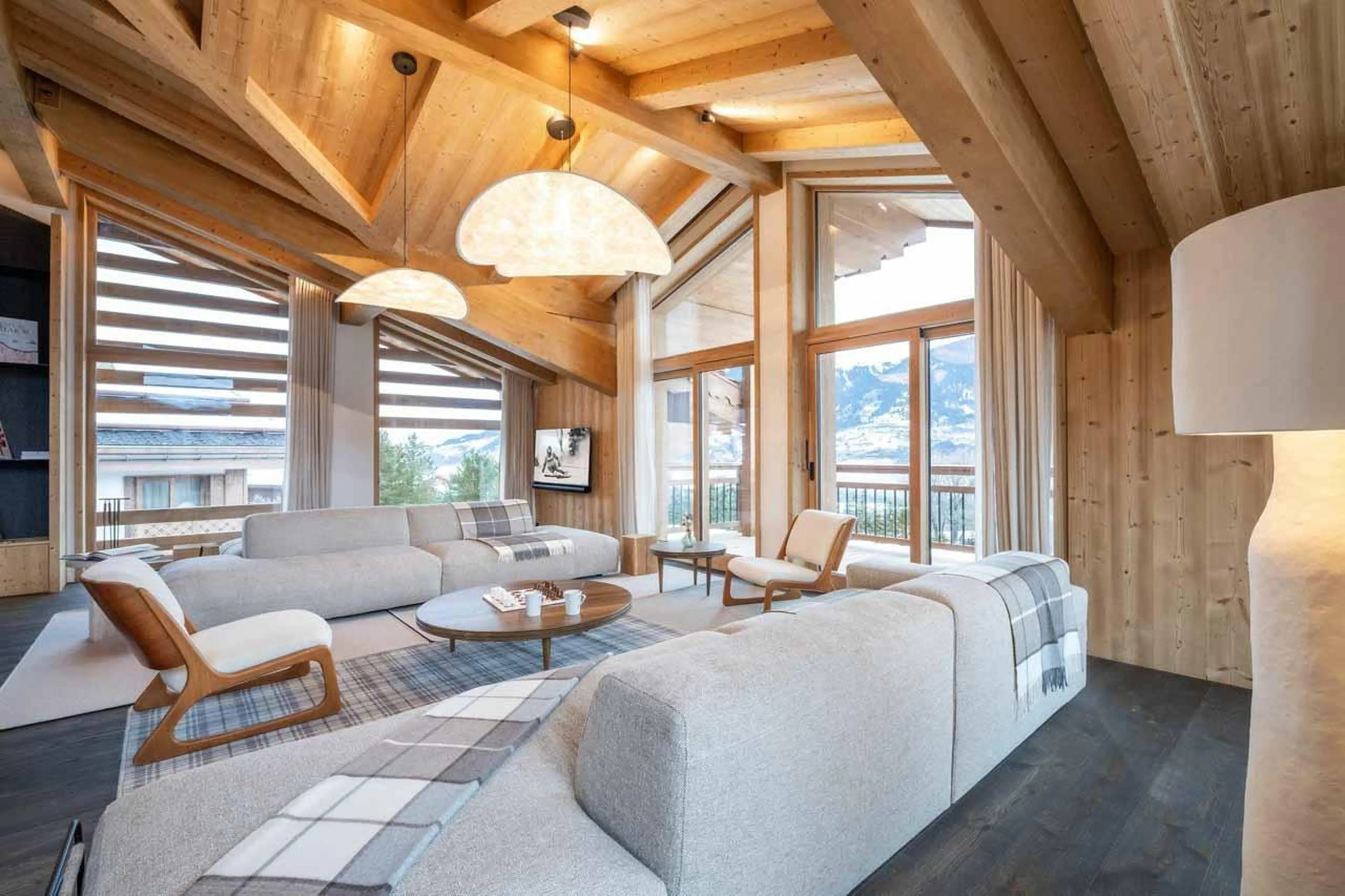 Sofas and armchairs beneath vaulted windows in Chalet Irbis, Courchevel Le Praz