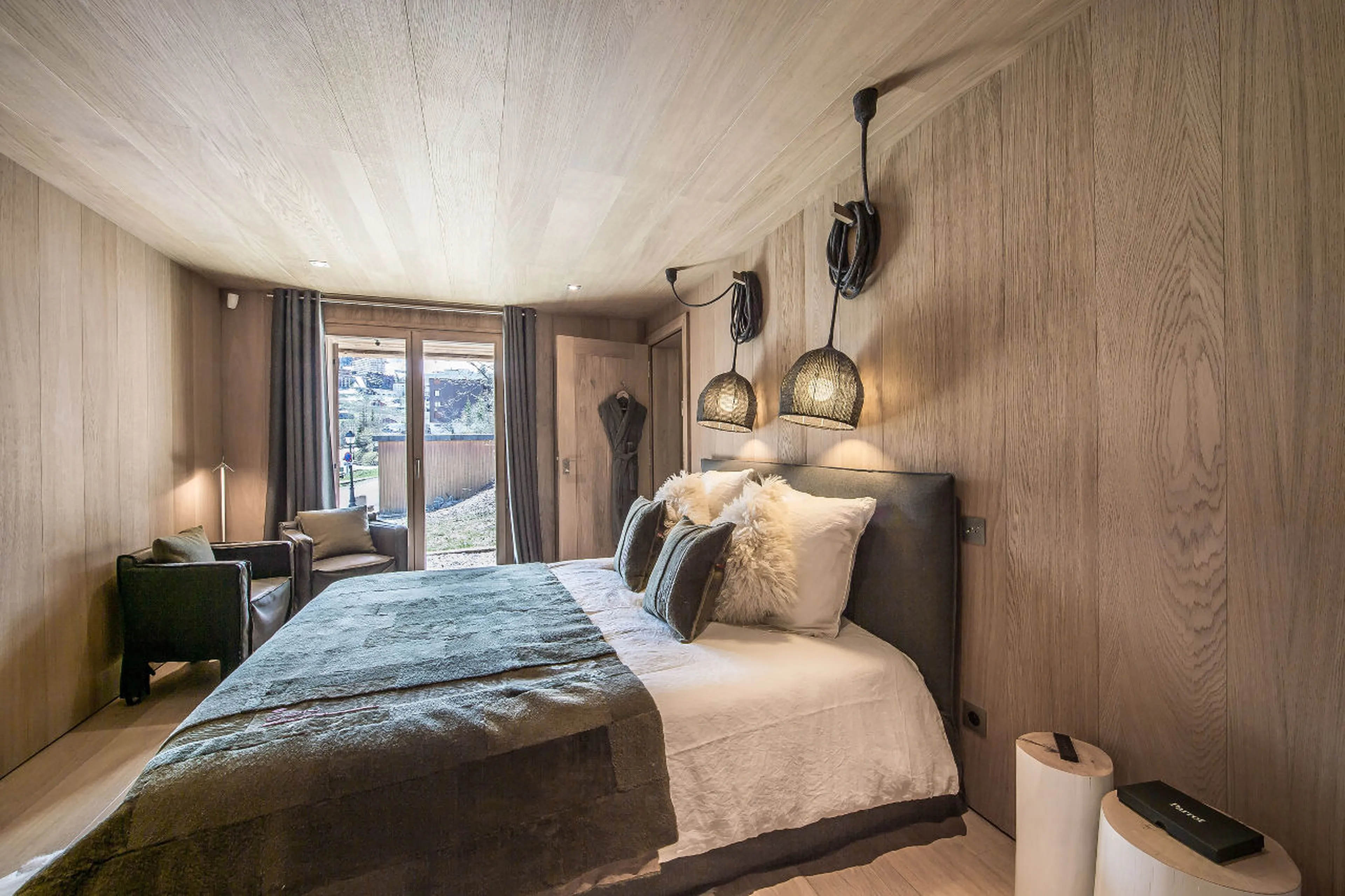 Double bedroom with patio access and en-suite shower room in Chalet Kibo in Courchevel
