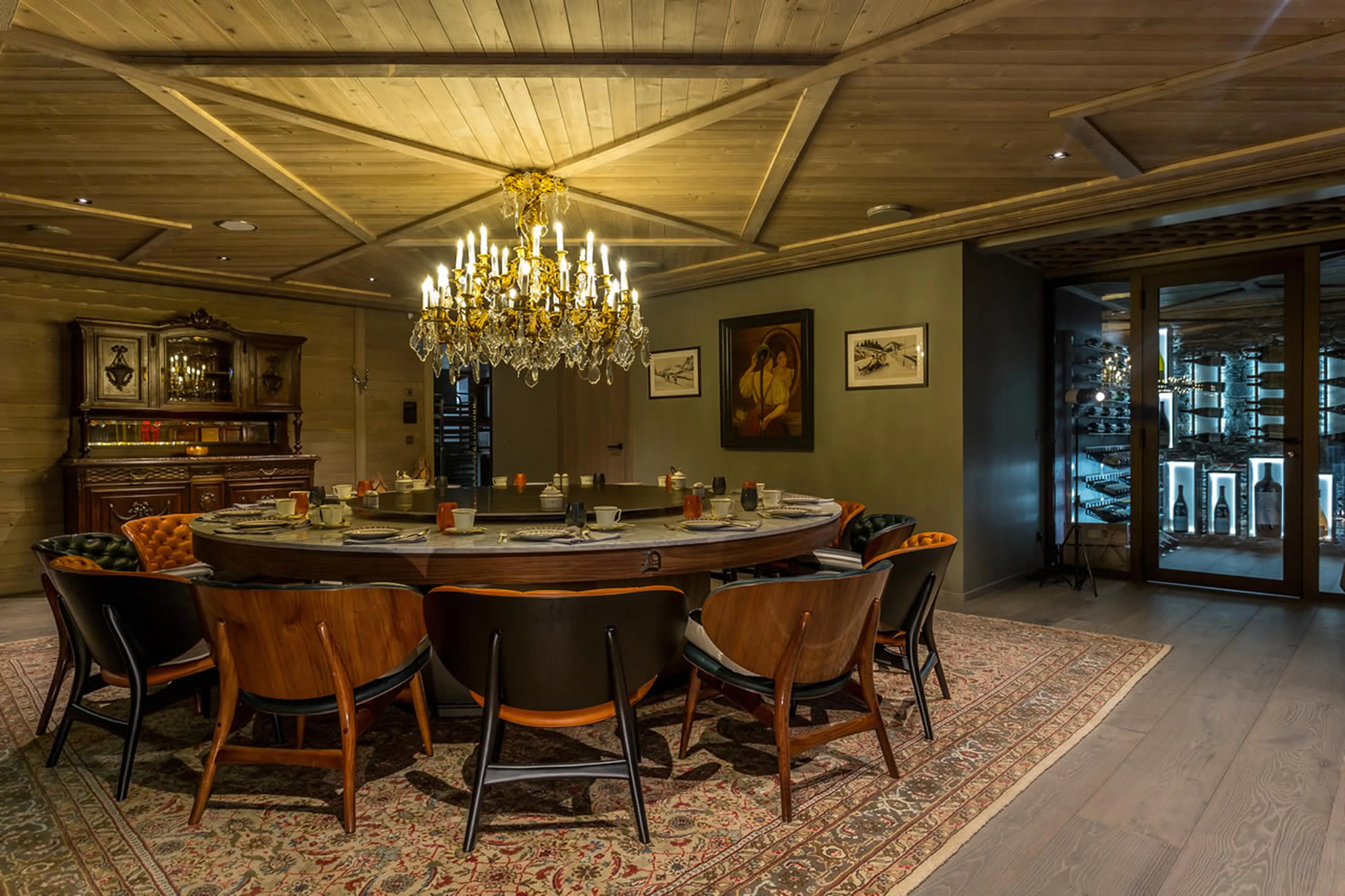 Dining area, with striking chandelier, opens onto the terrace of Chalet La Datcha in Val Thorens