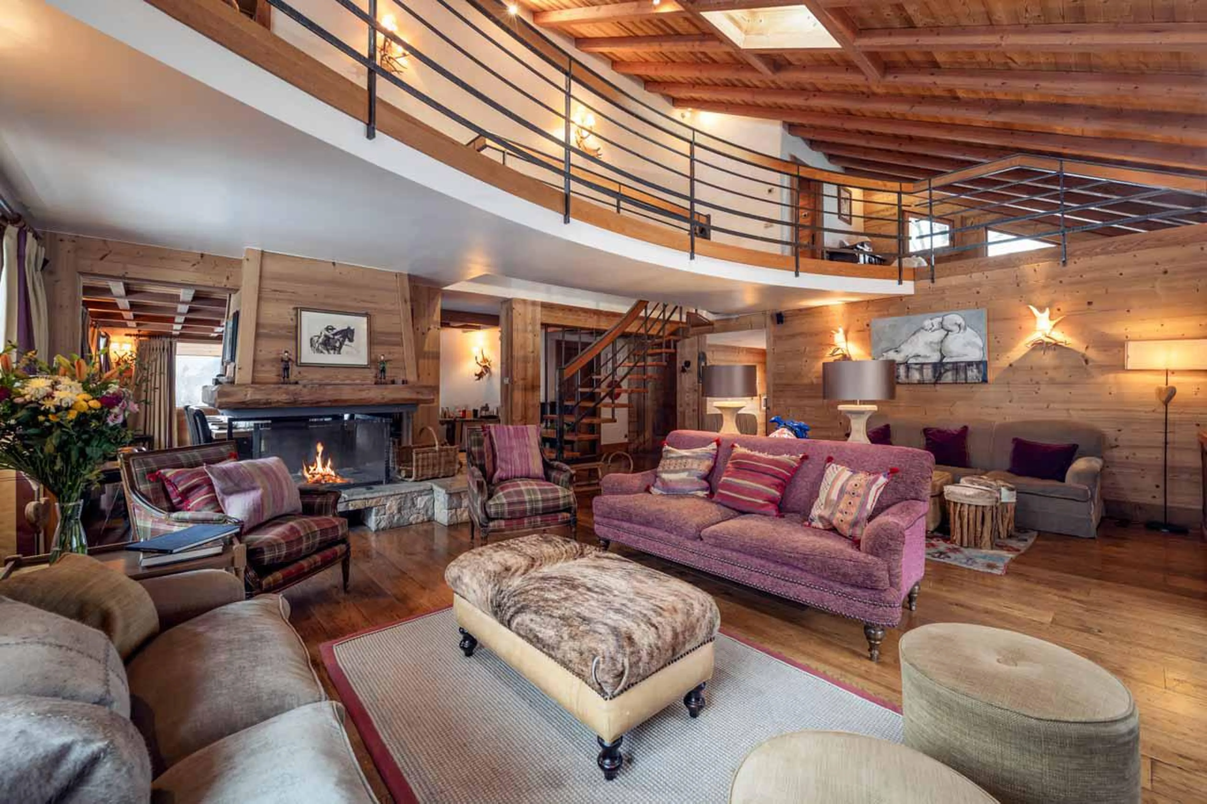Sitting room with central open log fire at Chalet Lapin Blanc in Meribel