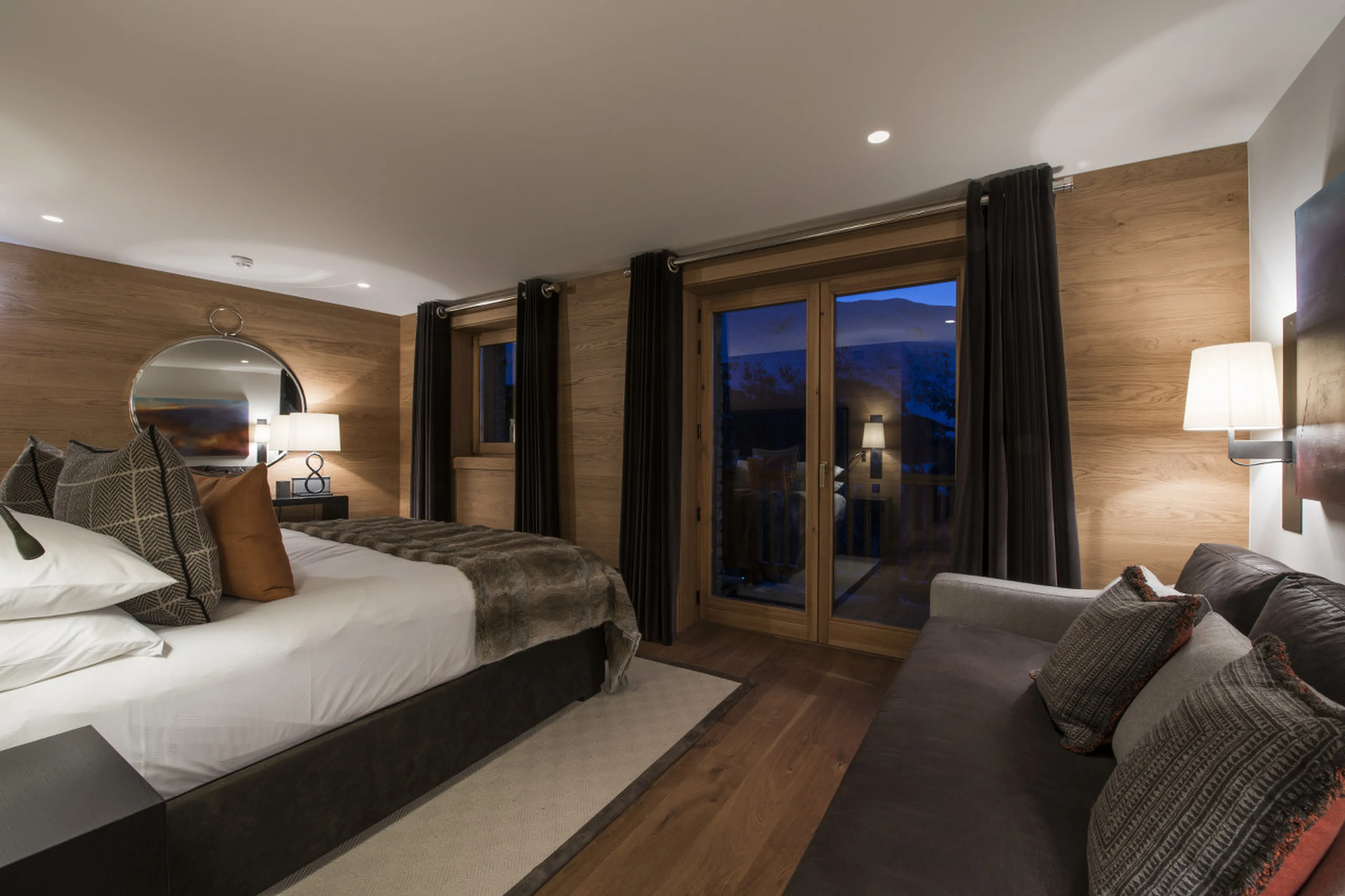 Double second master bedroom with sofa and balcony access in Chalet Le Grenier in Meribel