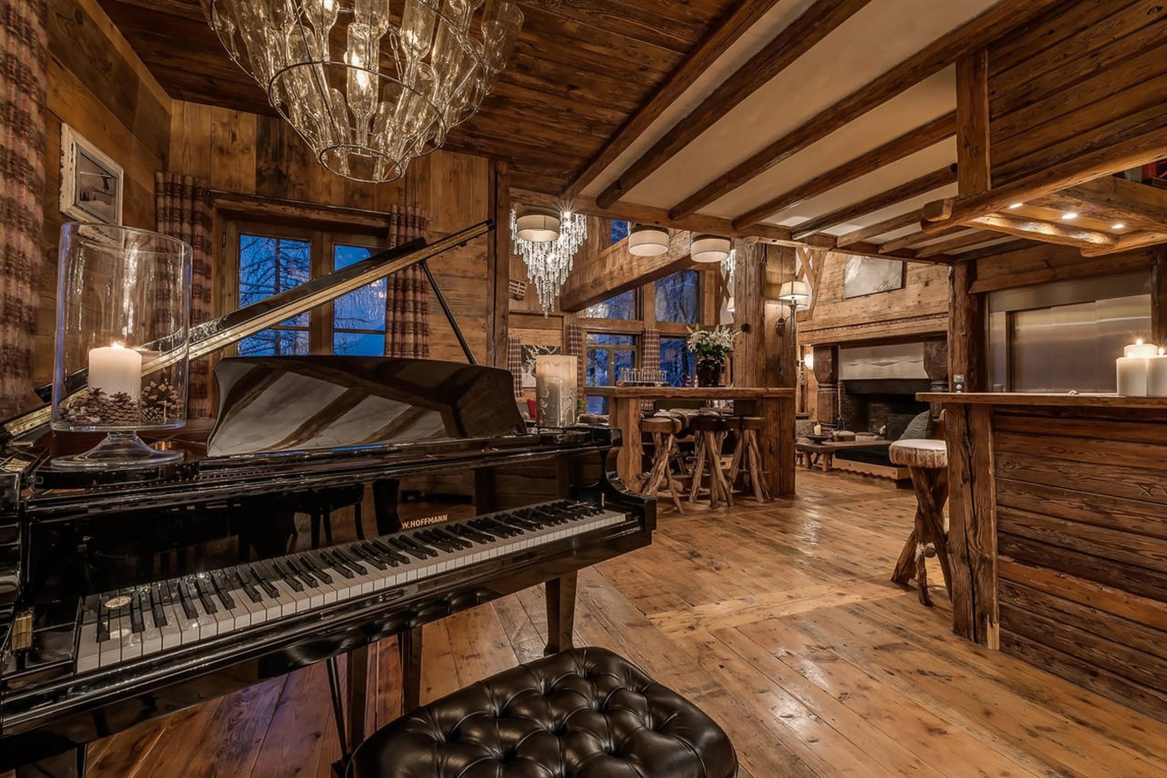 Grand piano and bar counter in living area of Chalet Le Rocher in Val d’Isere