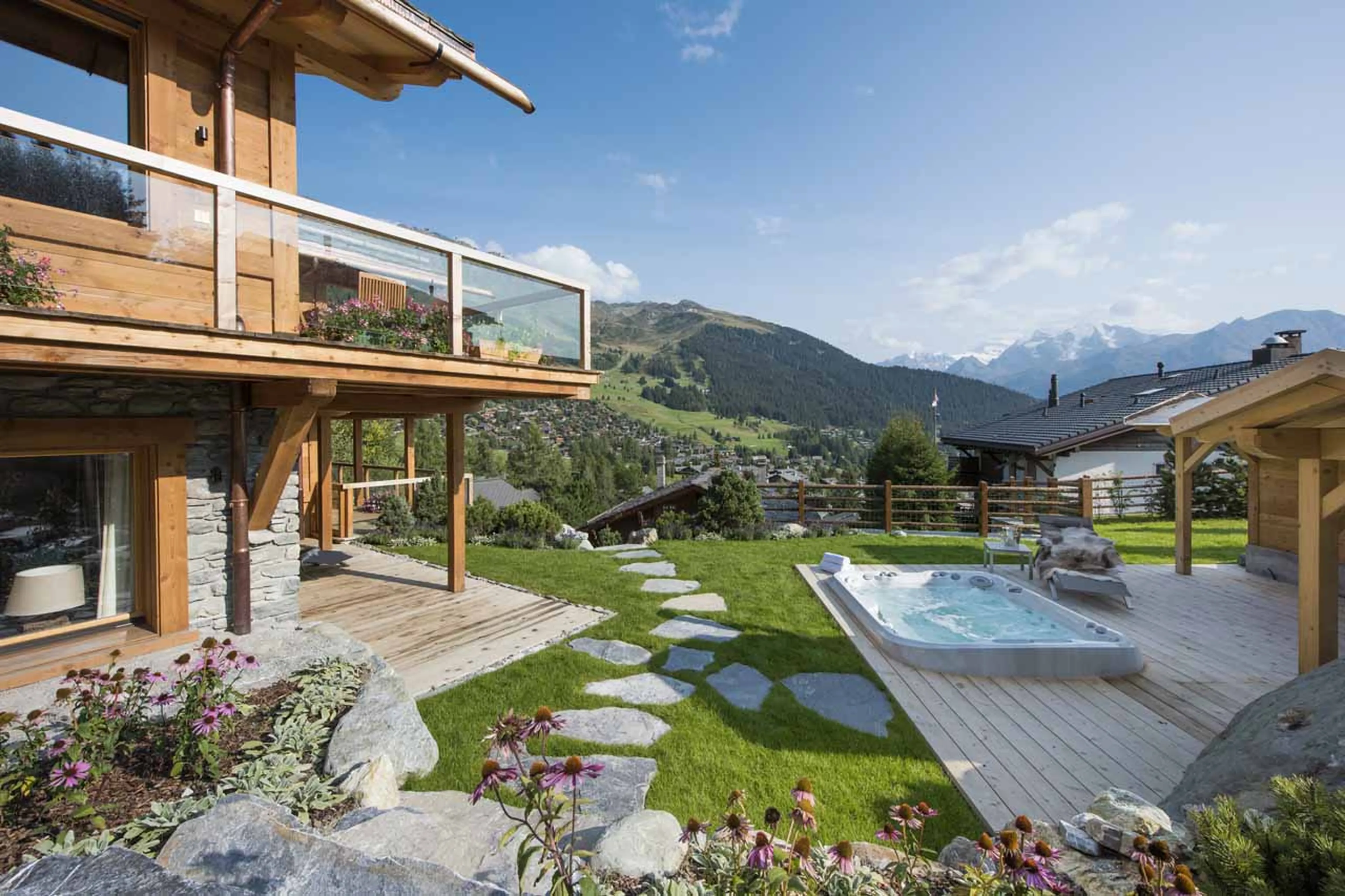 View of the chalet terrace and hot tub in summer at Chalet Les Etrennes in verbier