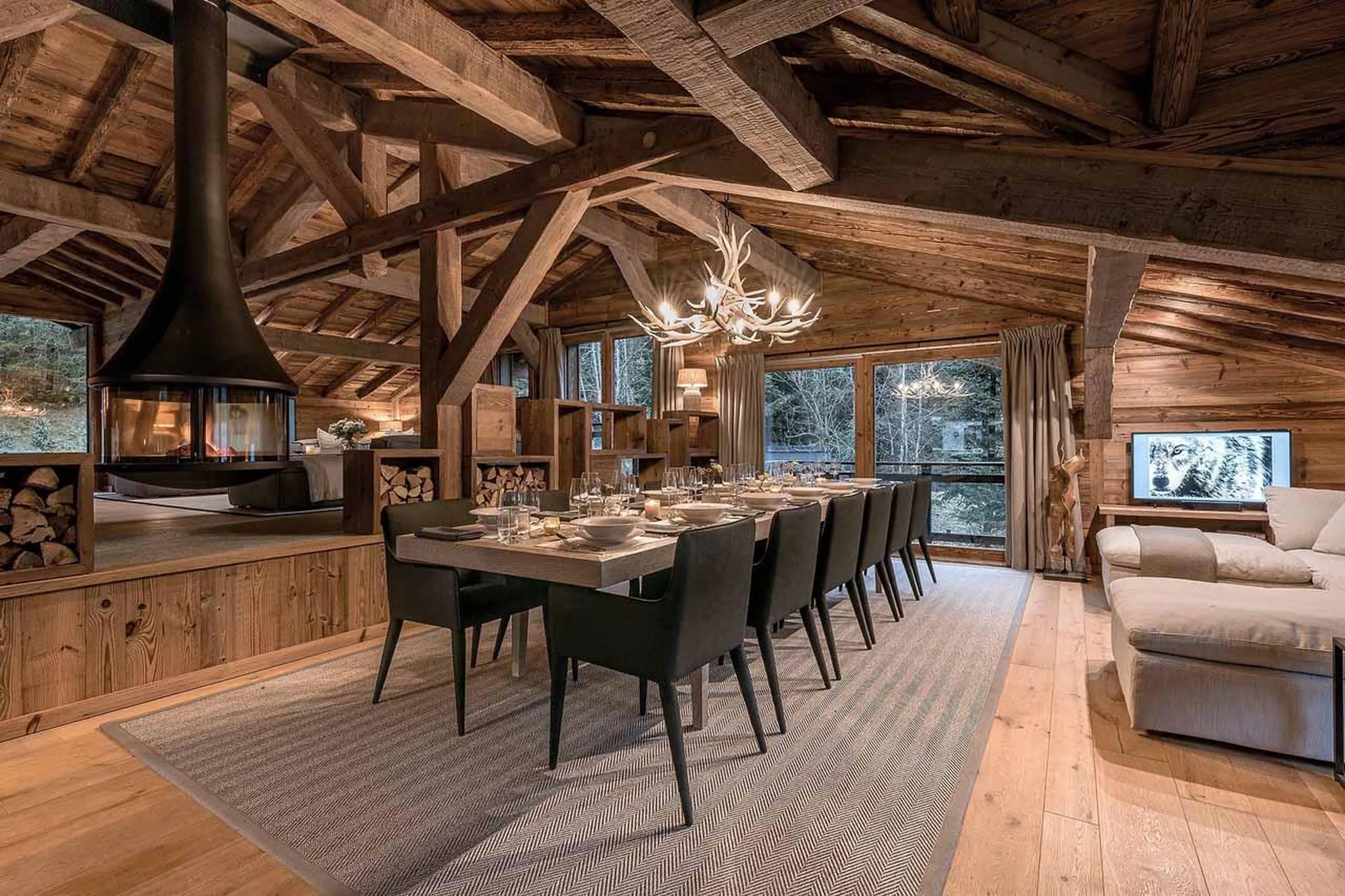 Dining area and living area separated by fireplace in Chalet Lupa, Chamonix