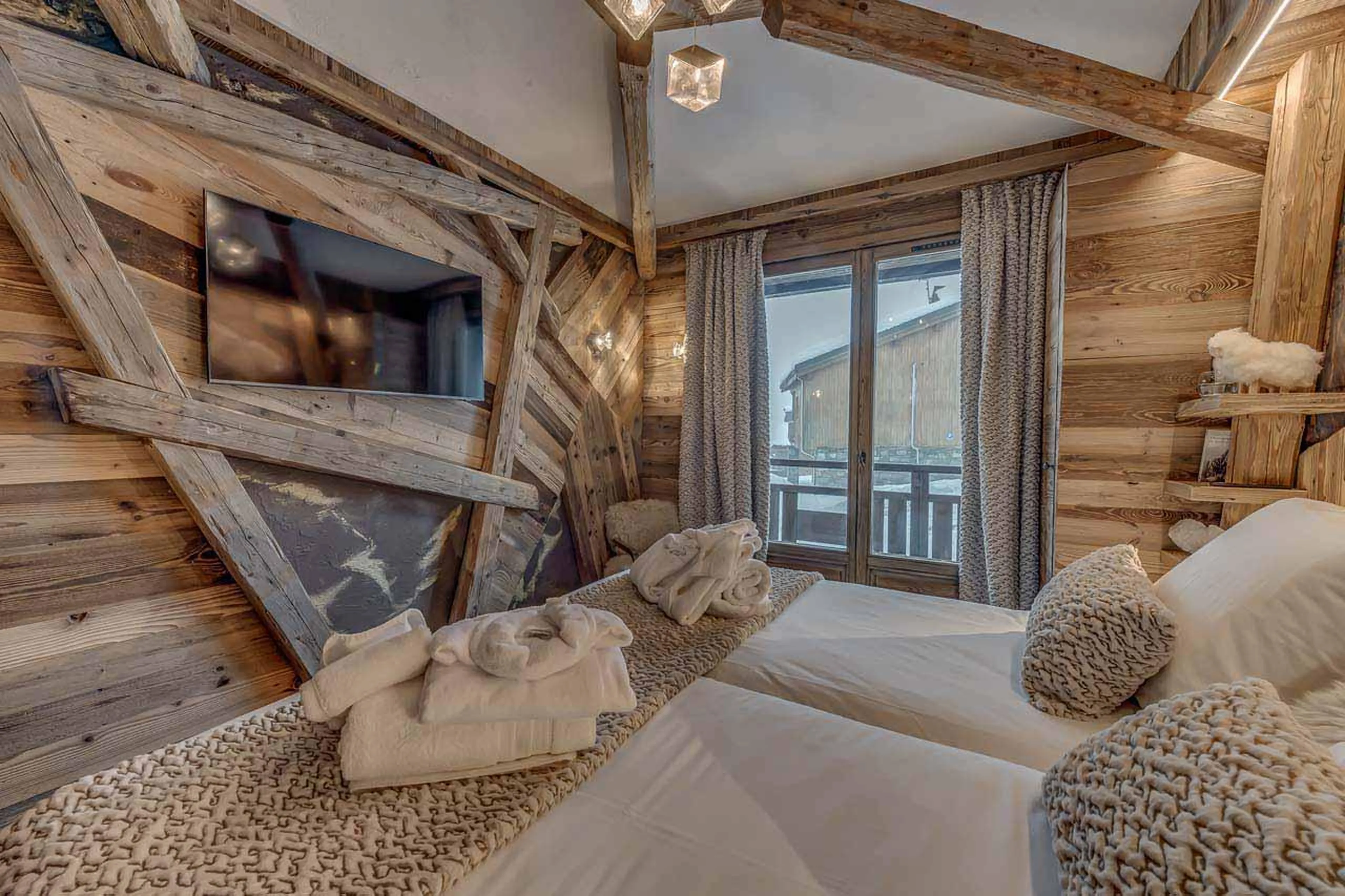 Spacious bedroom with TV and balcony access at Chalet Macha in Tignes