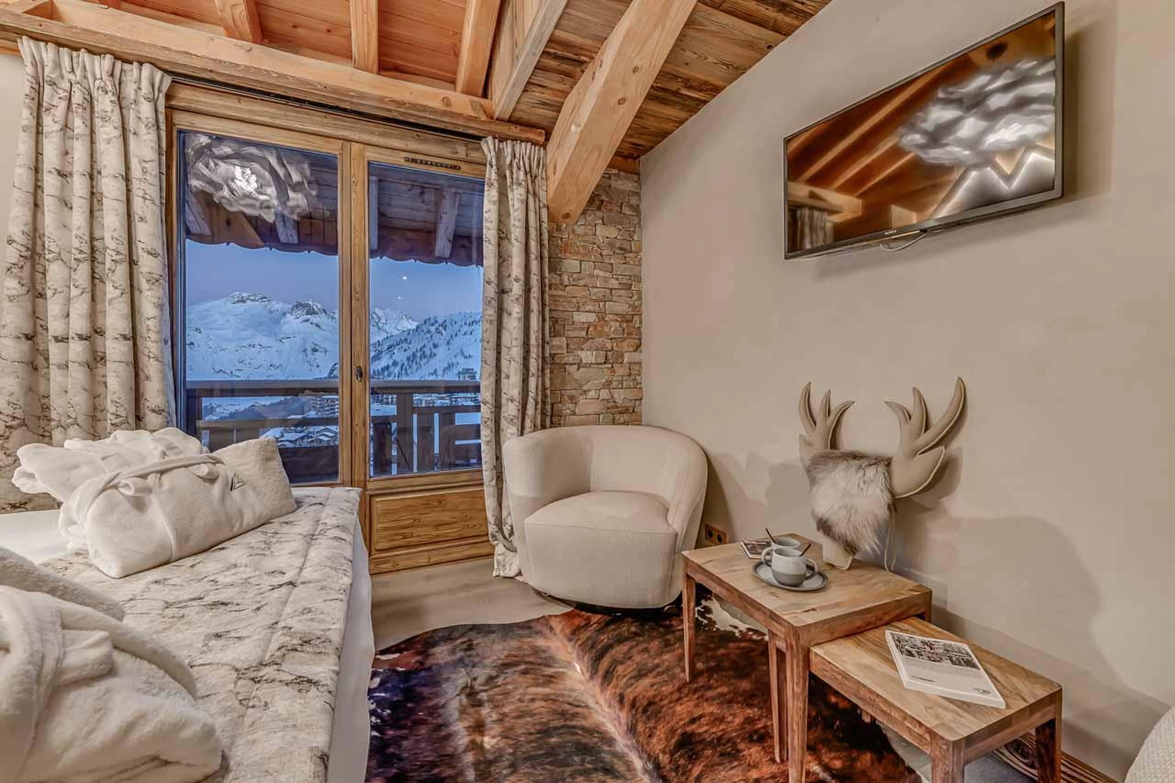 Bedroom with TV and east facing balcony at Chalet Macha in Tignes
