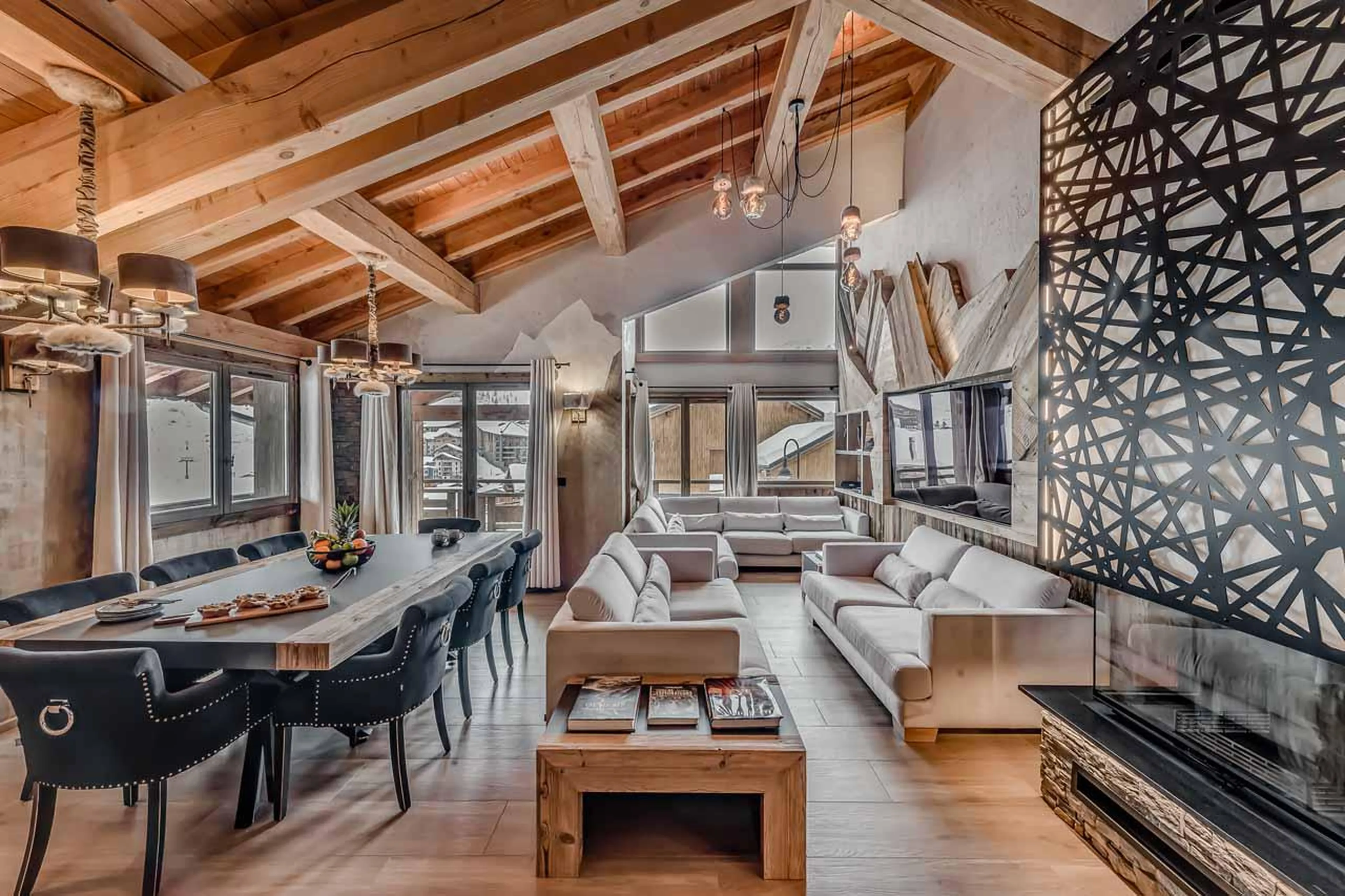 Modern U-shaped sofa area with fireplace and TV at Chalet Macha in Tignes