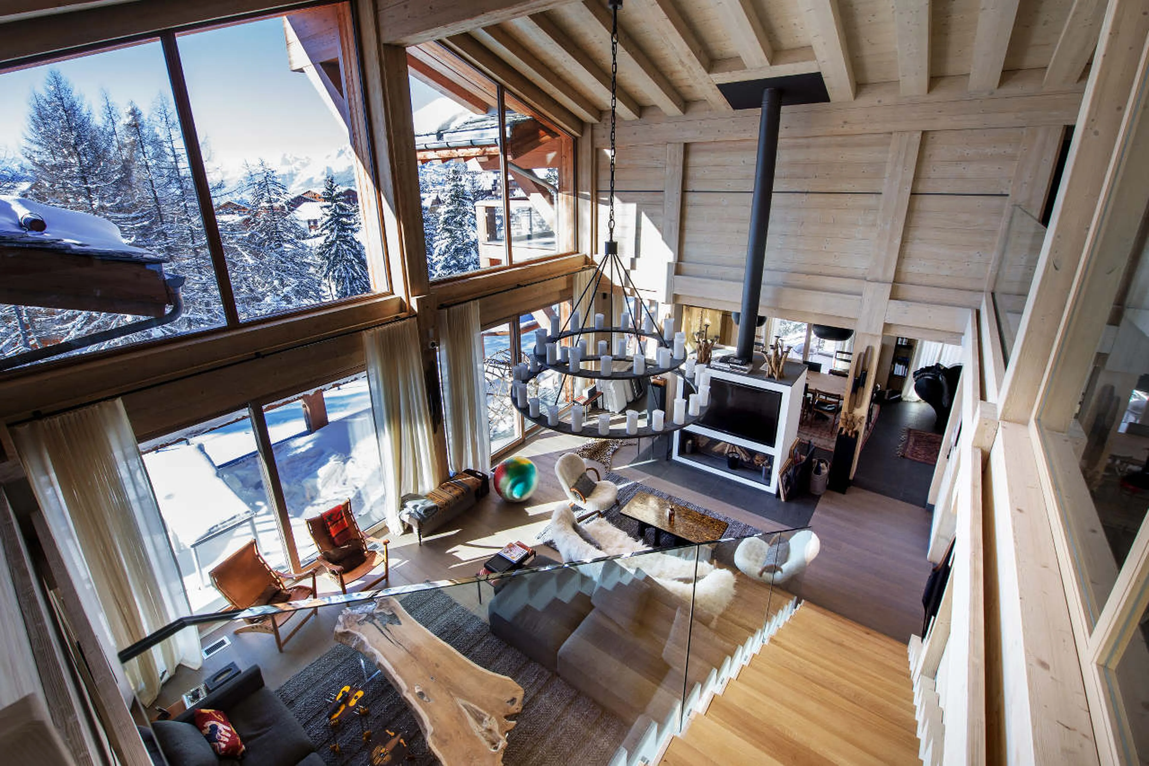 Double height living room with vaulted ceilings and balcony access in Chalet Migui in Crans-Montana