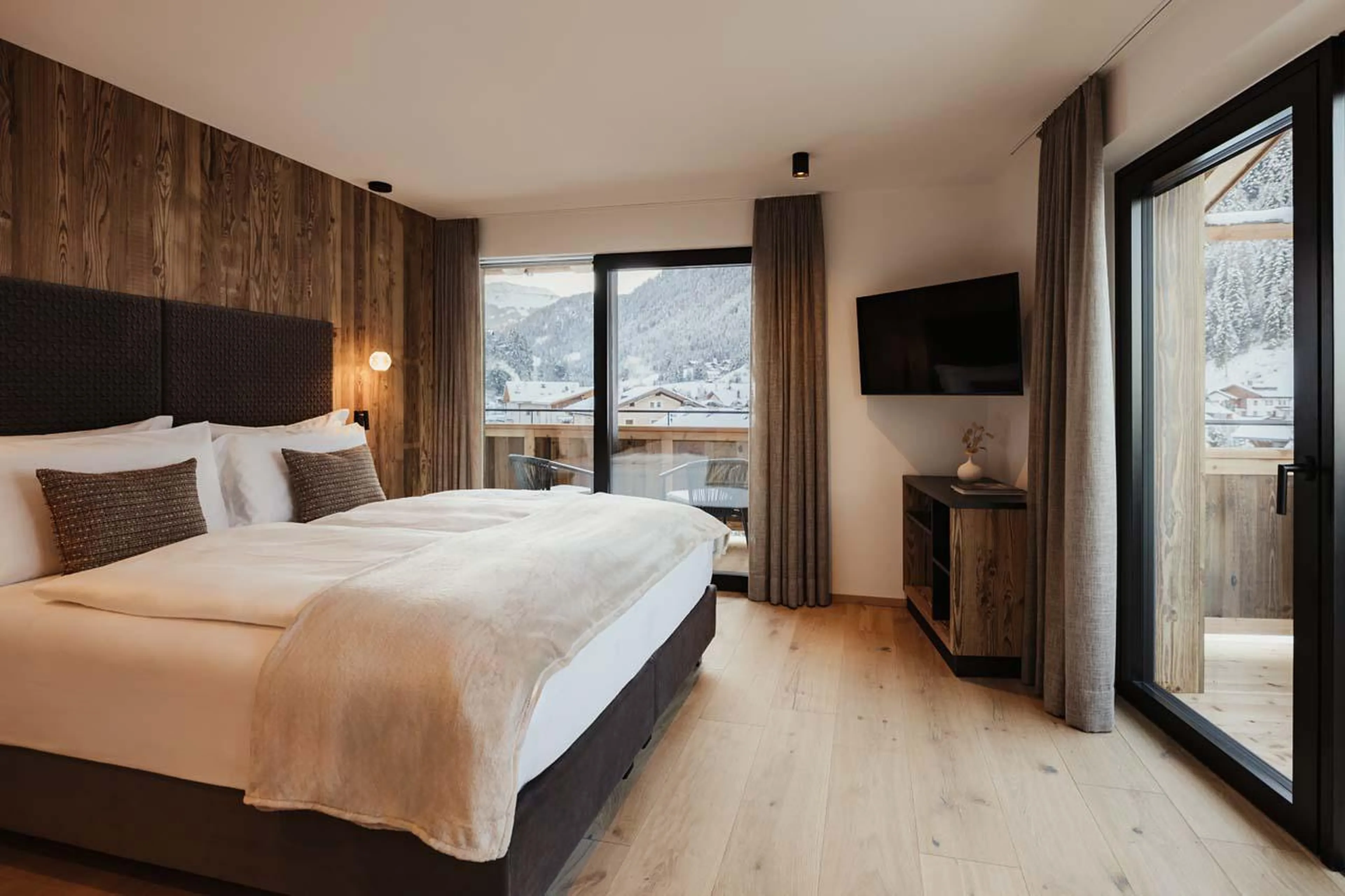 Double/twin bedroom with TV, balcony access and en-suite shower room at Chalet Mile 2 in Val Gardena