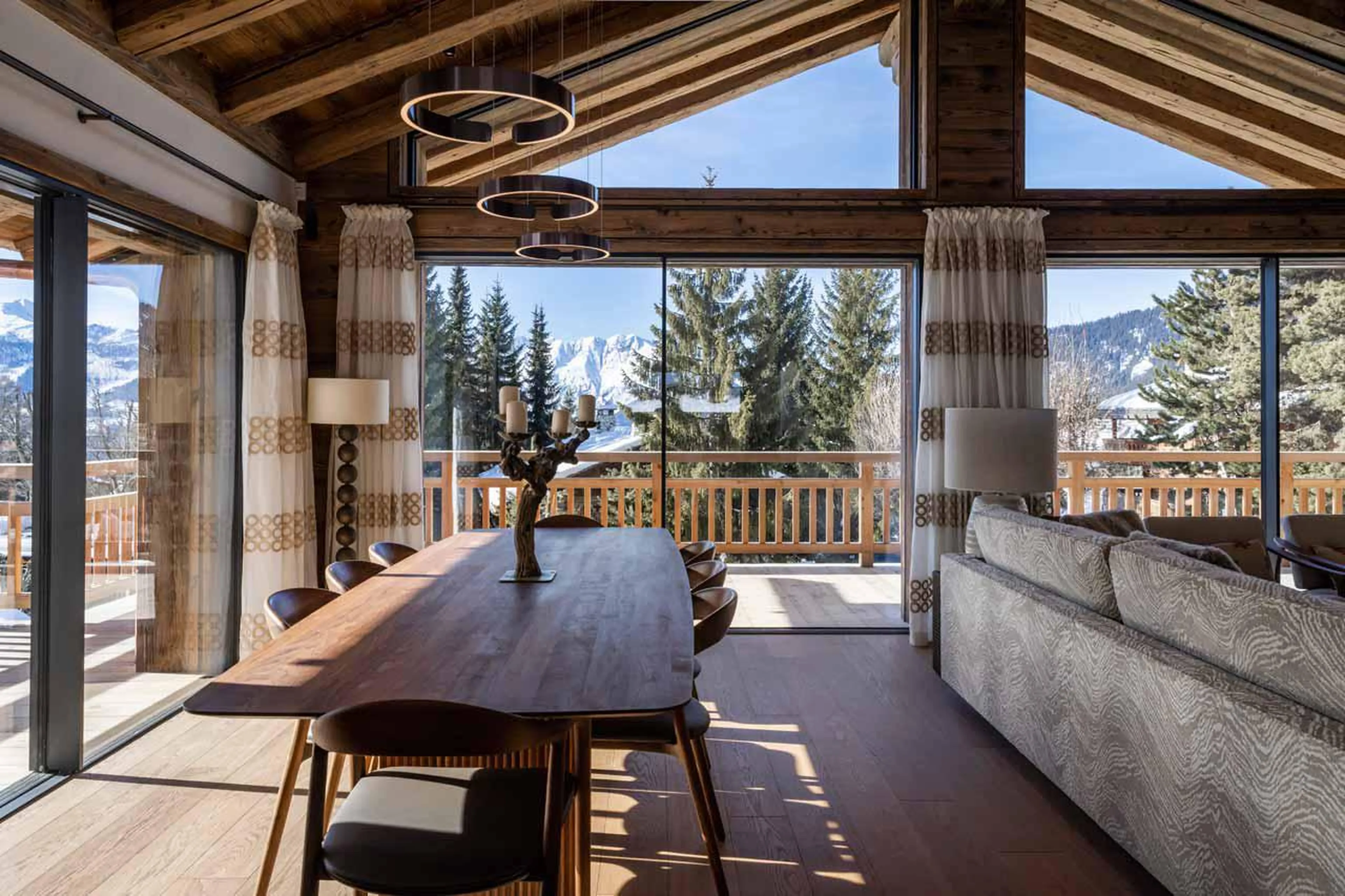 Elegant dining table with stunning floor-to-ceiling windows at Chalet Munro in Verbier