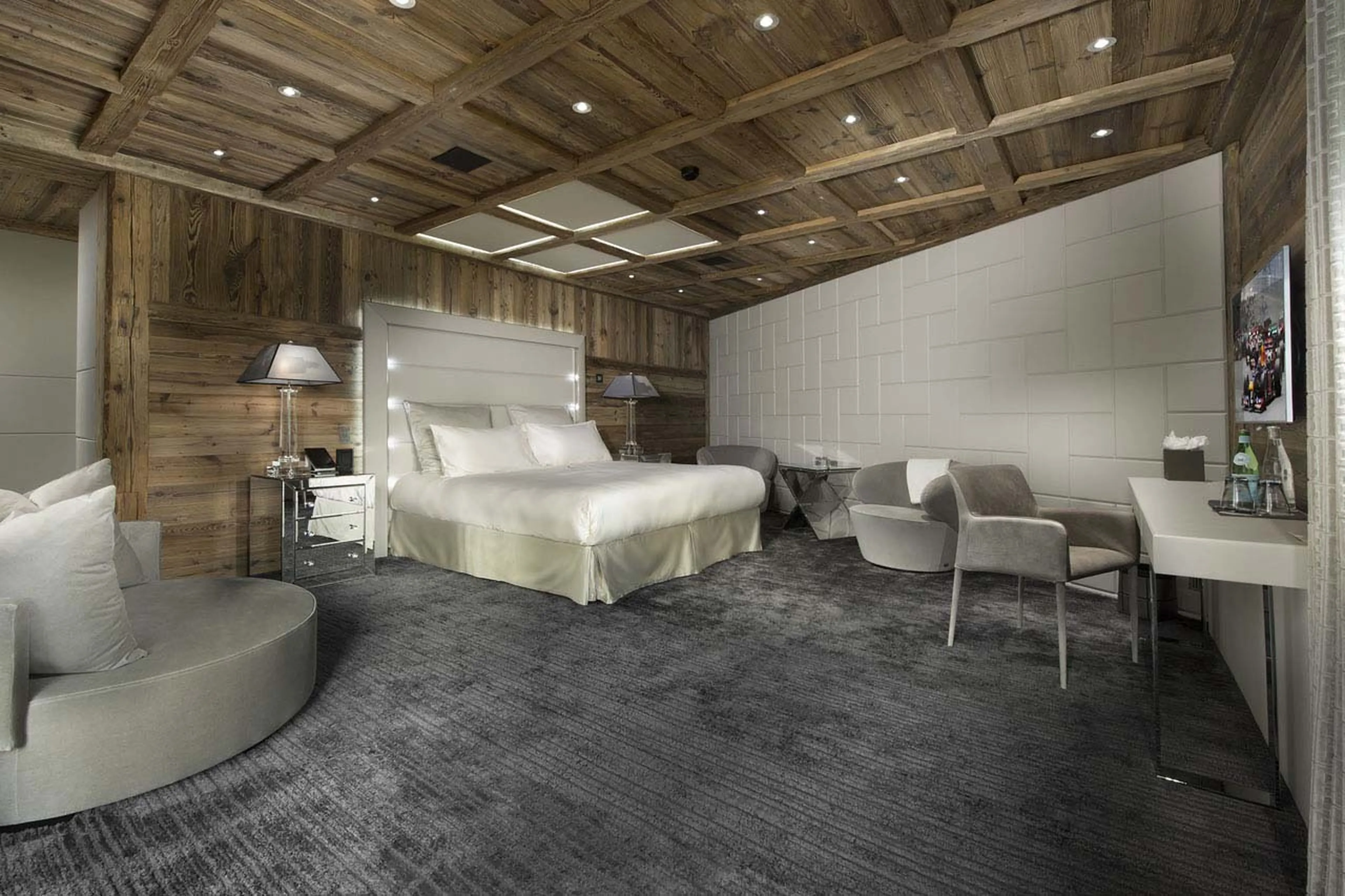 En suite bedroom with king-size bed and sitting area in Chalet Owens of Courchevel 1850